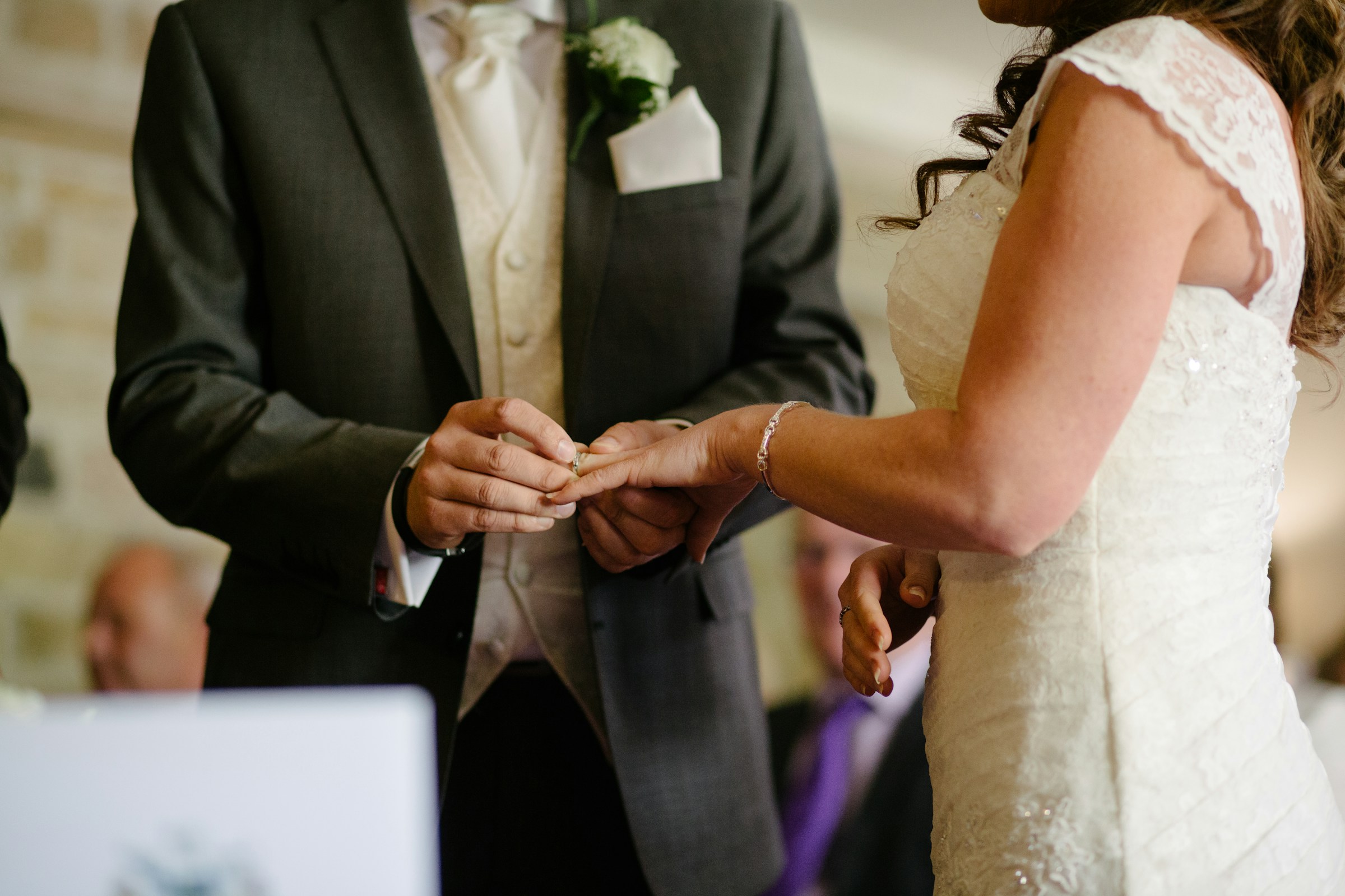A closeup of a groom placing a wedding ring on his bride's finger | Source: Unsplash