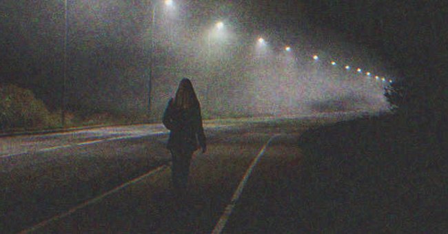 A woman walking down the street at night | Source: Shutterstock
