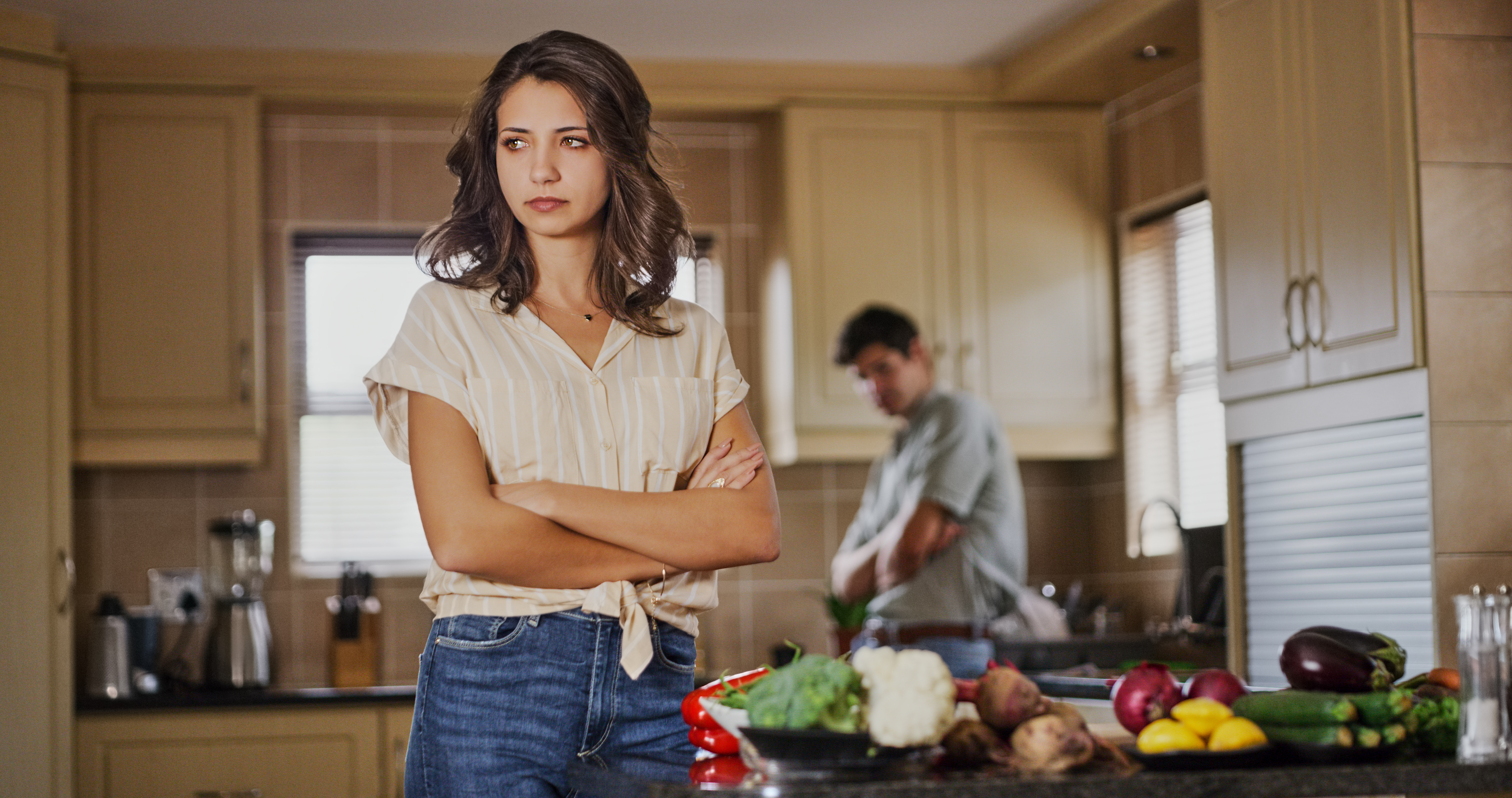 An upset woman standing in the foreground while a man stands in the background | Source: Getty Images