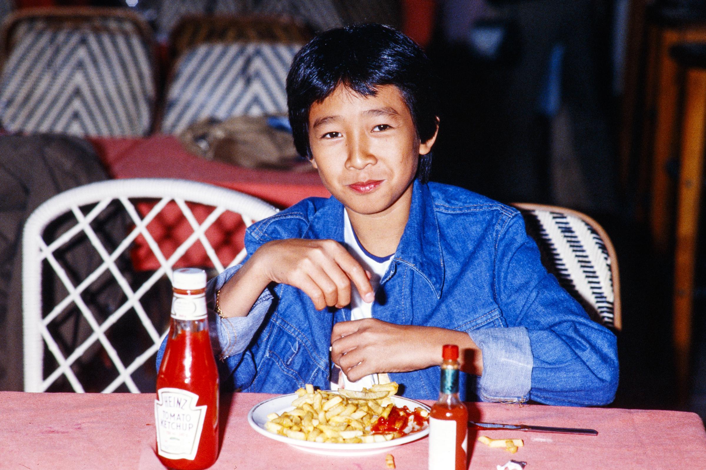 Ke Huy Quan at a restaurant during the promotion of the film "Indiana Jones and the Temple of Doom," in Paris, in September 1984 | Source: Getty Images
