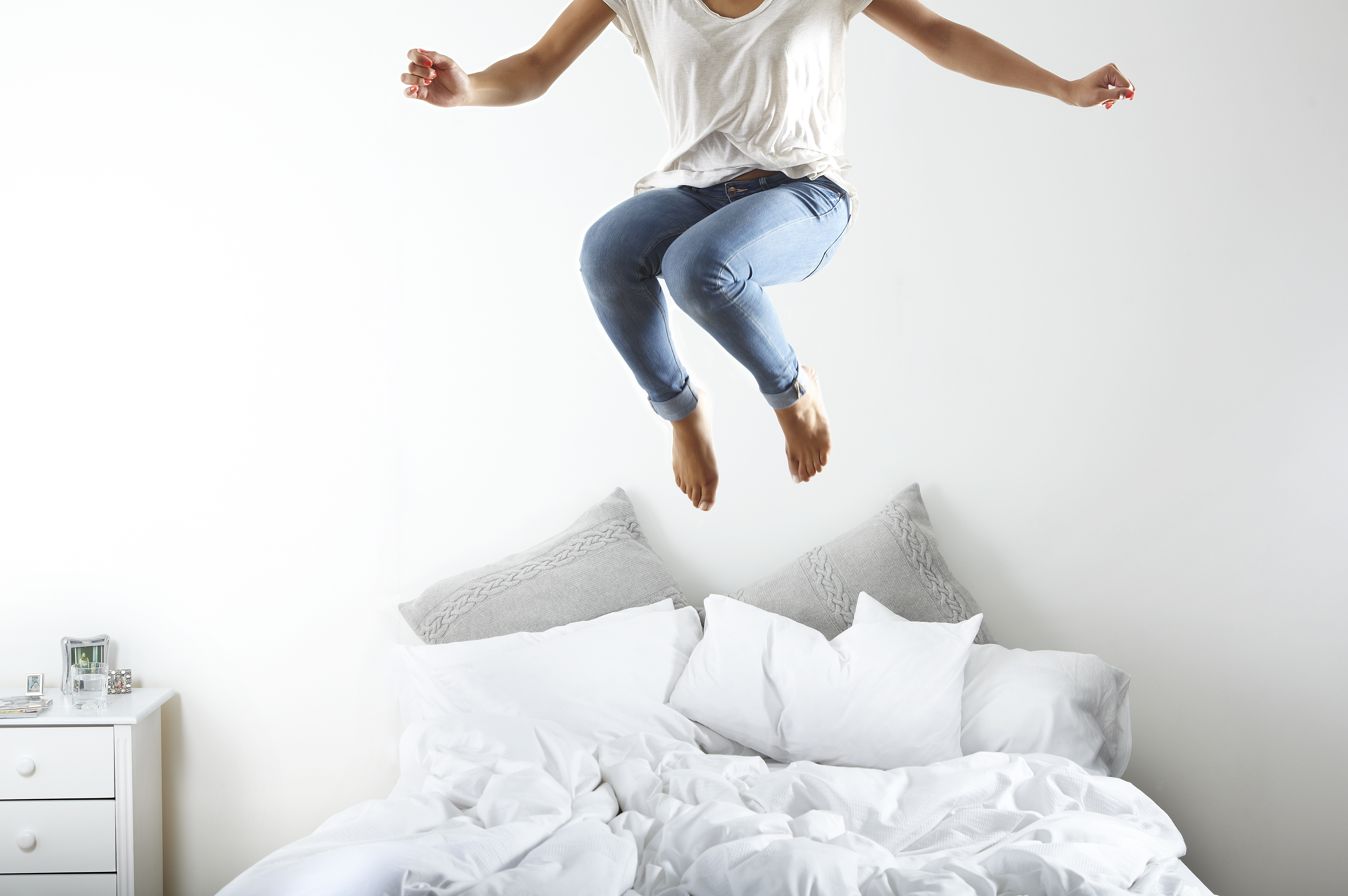 Portrait of woman jumping on bed | Source: Getty Images
