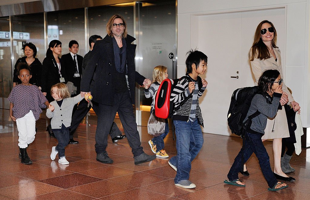 Accompanied by their six children, Brad Pitt and Angellina Jolie appear before photographers upon their arrival at Haneda Airport in Tokyo, November 2011 | Source: Getty Images