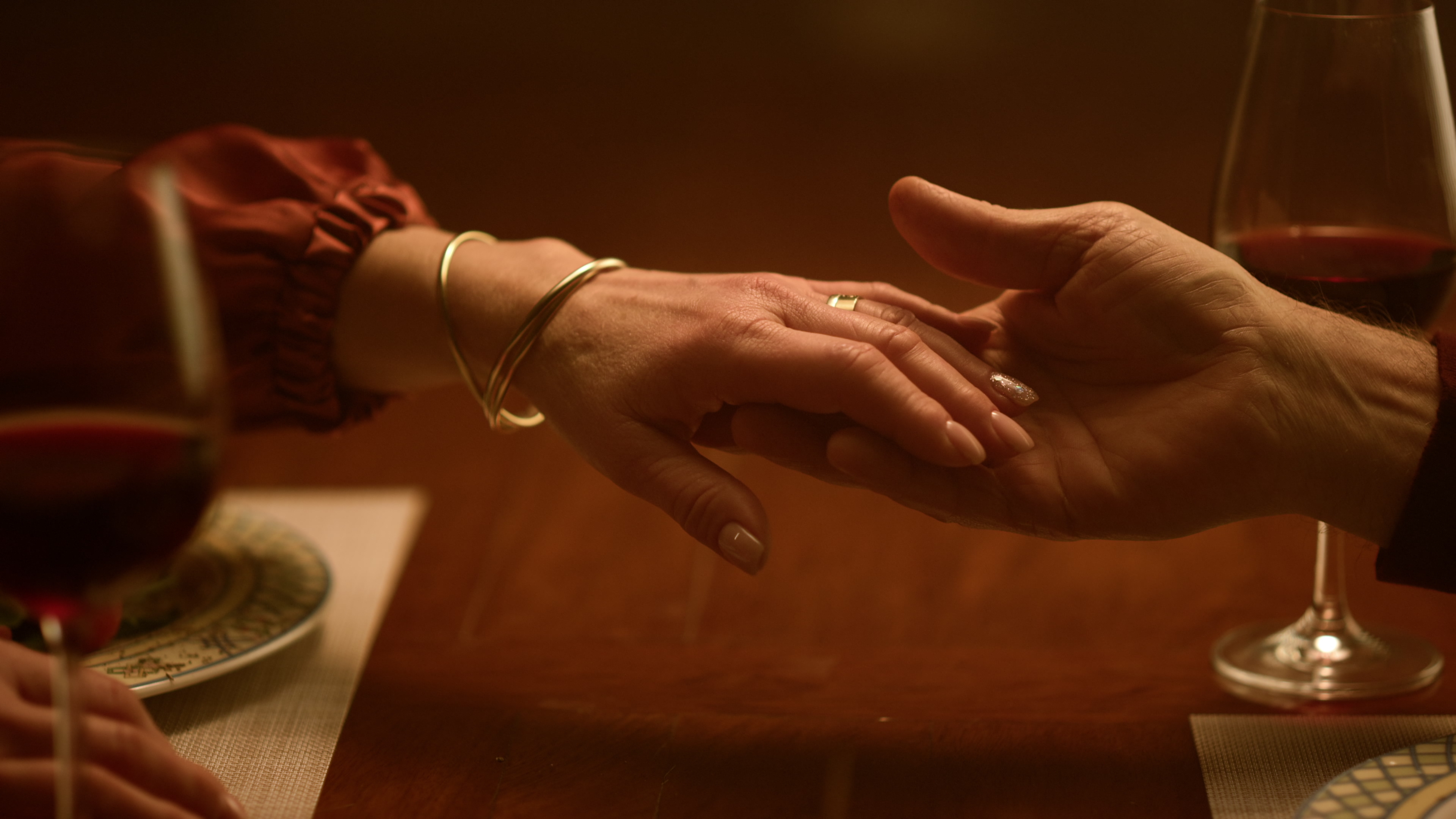 A close-up photo of a couple holding hands during dinner | Source: Shutterstock