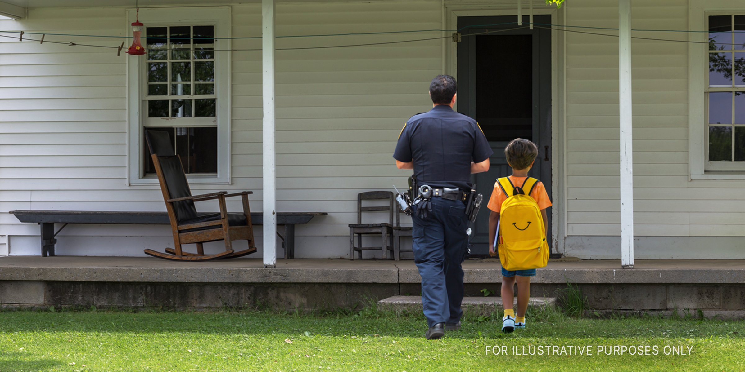 Young boy and policeman walk towards a house | Source: Shutterstock