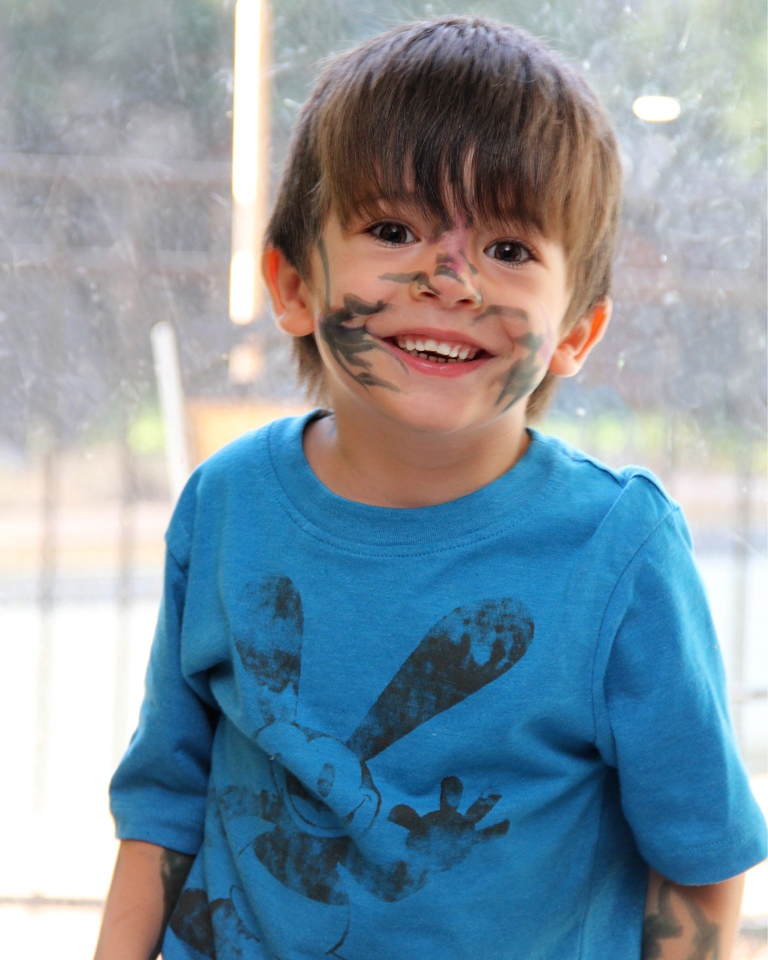 Pictured - A little boy with ink prints on his face smiles while having fun | Source: Pixabay 