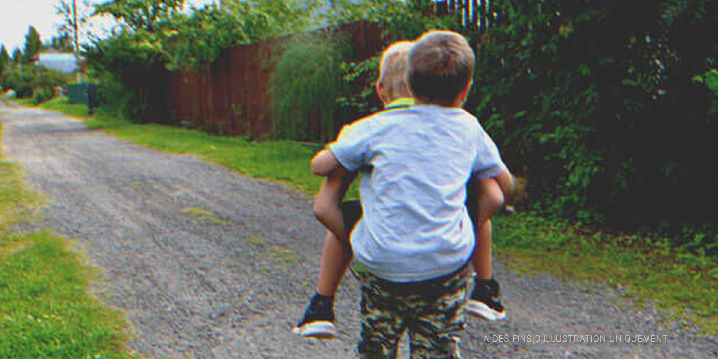 Un petit garçon porte son ami dans son dos | Photo : Shutterstock