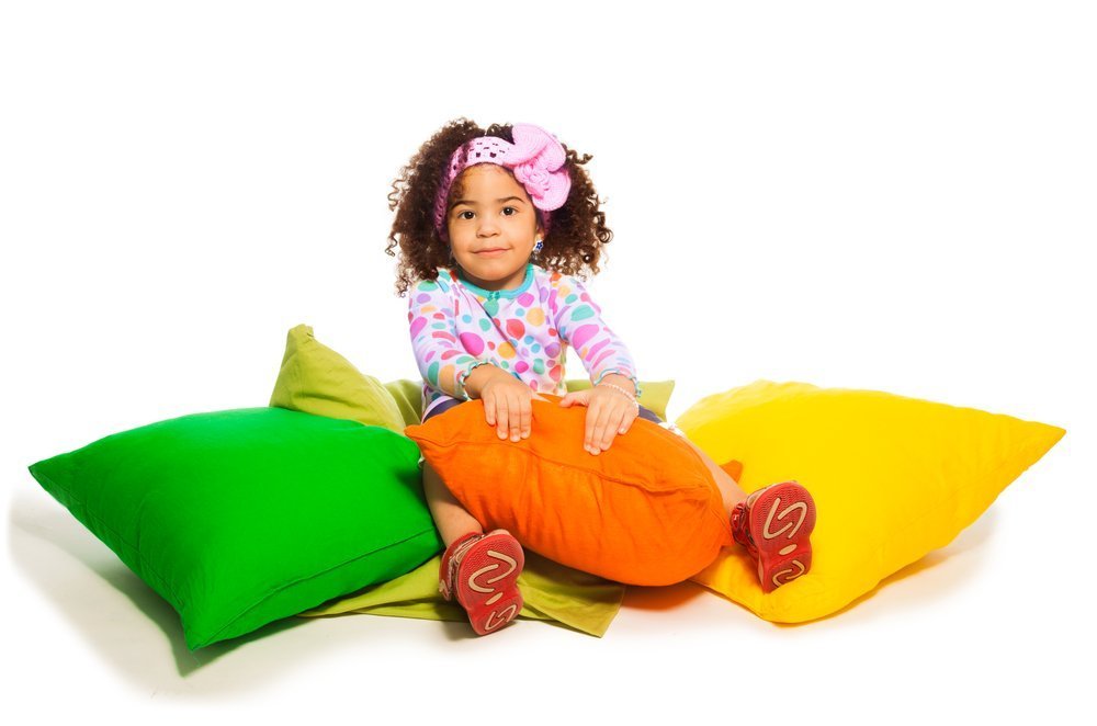 Girl sitting on pillows | Photo: Shutterstock