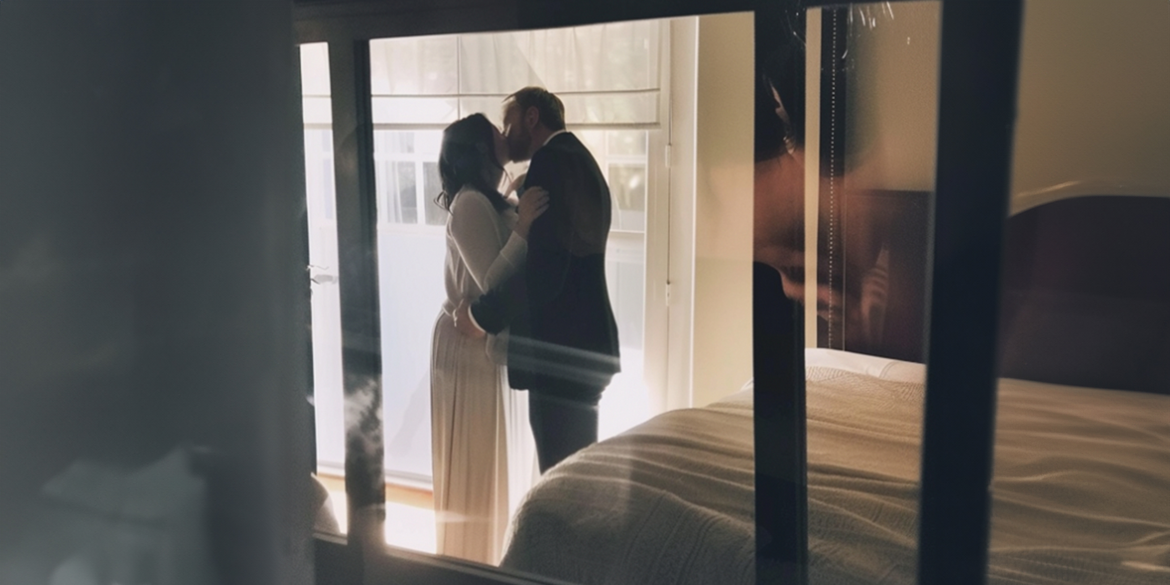 A couple kissing behind a window | Source: Amomama