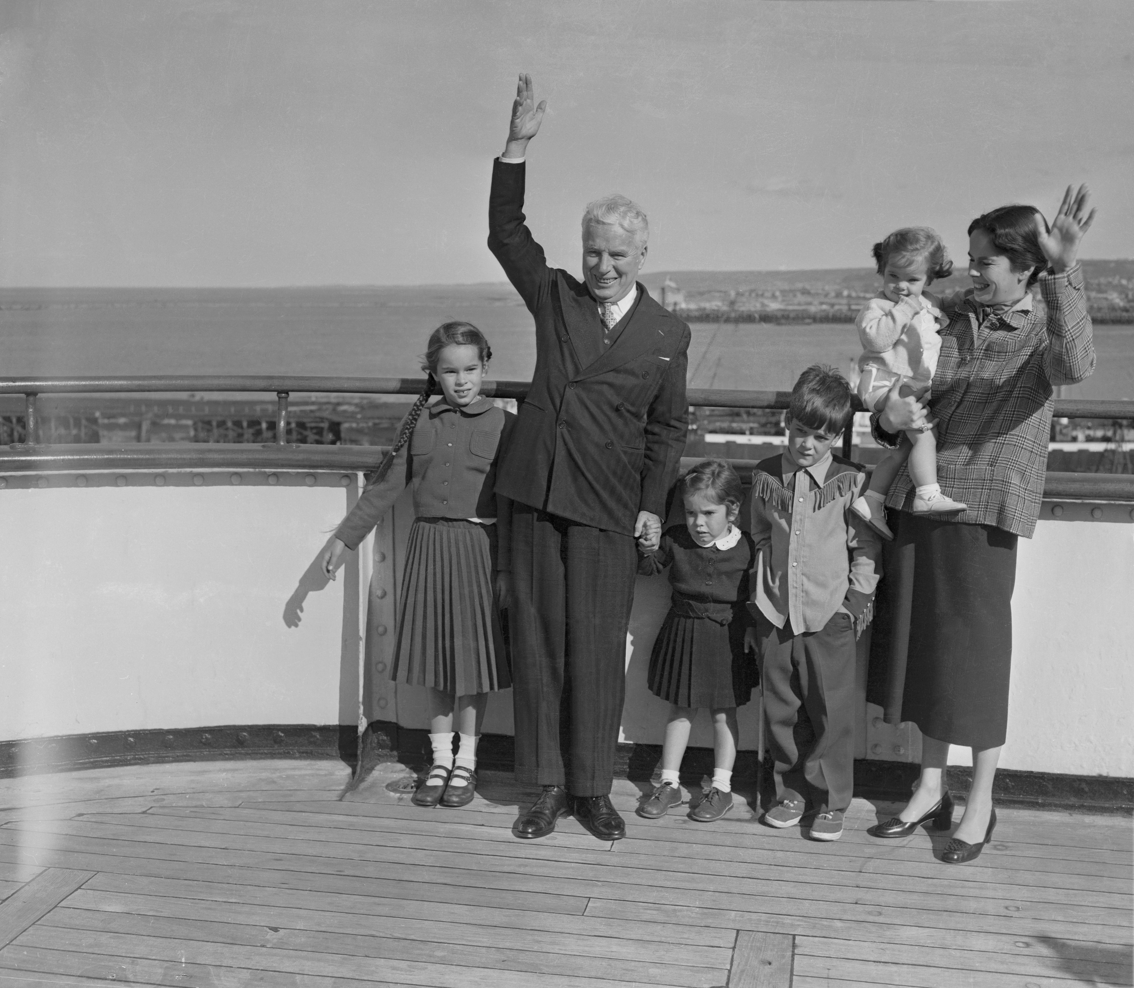 Charlie Chaplin arrives in Cherbourg, France, on the deck of the liner Queen Elizabeth, with his wife, Oona, and children on September 22, 1952 | Source: Getty Images