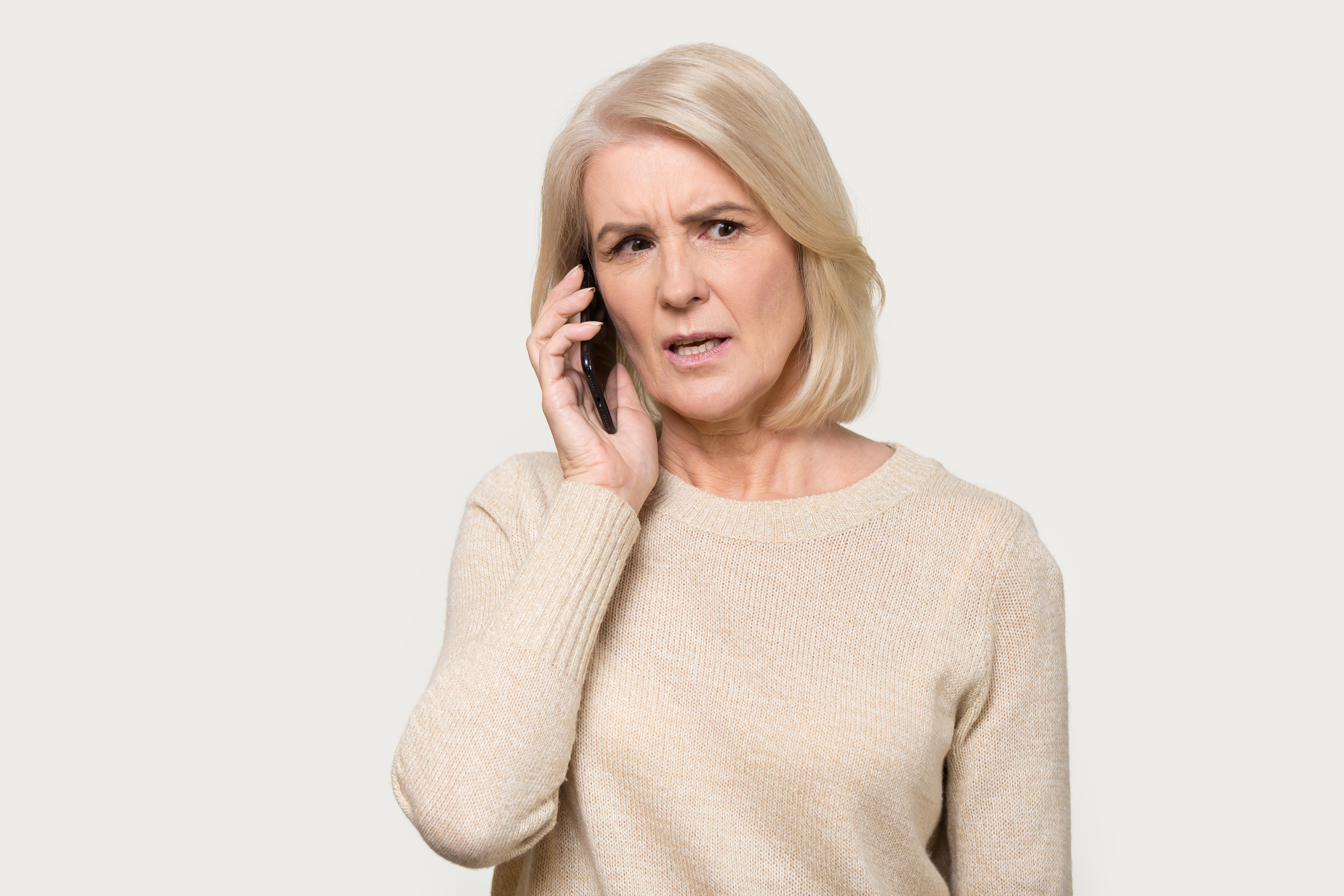 Woman talking on phone with worried expression | Source: Shutterstock
