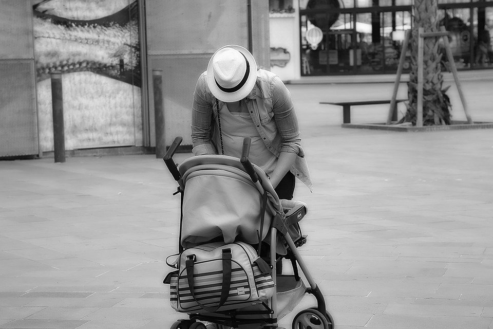 Une mère avec un chapeau devant la poussette | Photo: Pixabay
