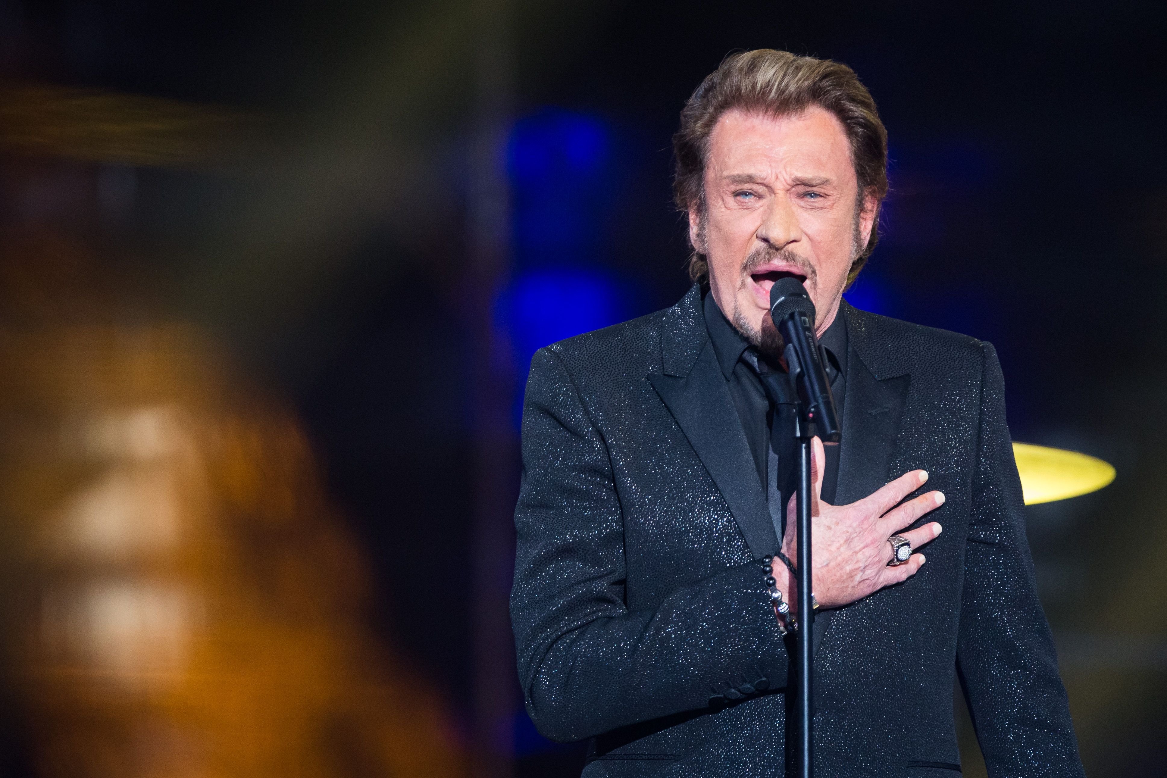 Johnny Hallyday se produit sur scène dans le cadre du Téléthon 2014 de France Télévision à Paris, France. | Photo : Getty Images