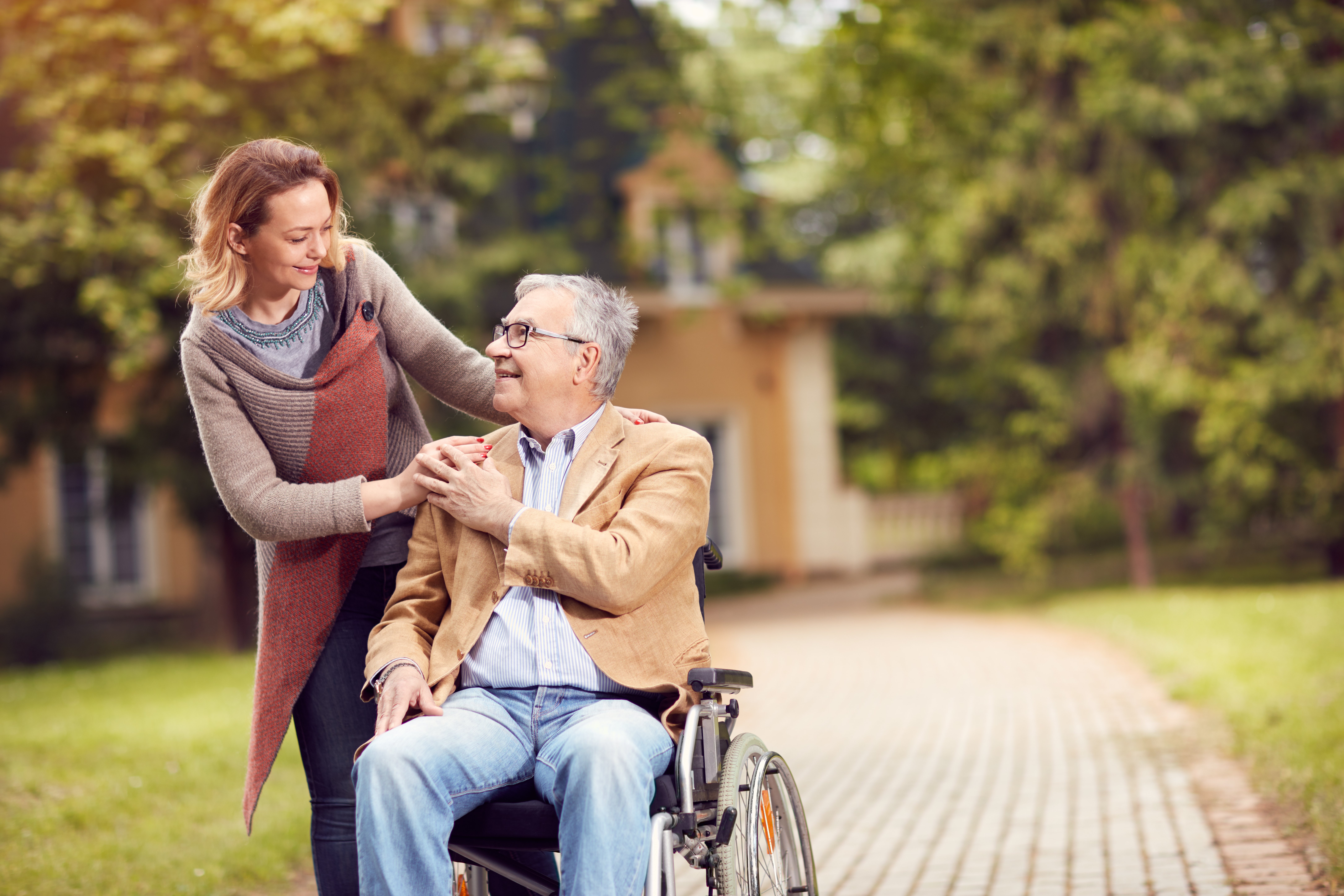 Mujer cuida de anciano en silla de ruedas. | Foto: Shutterstock