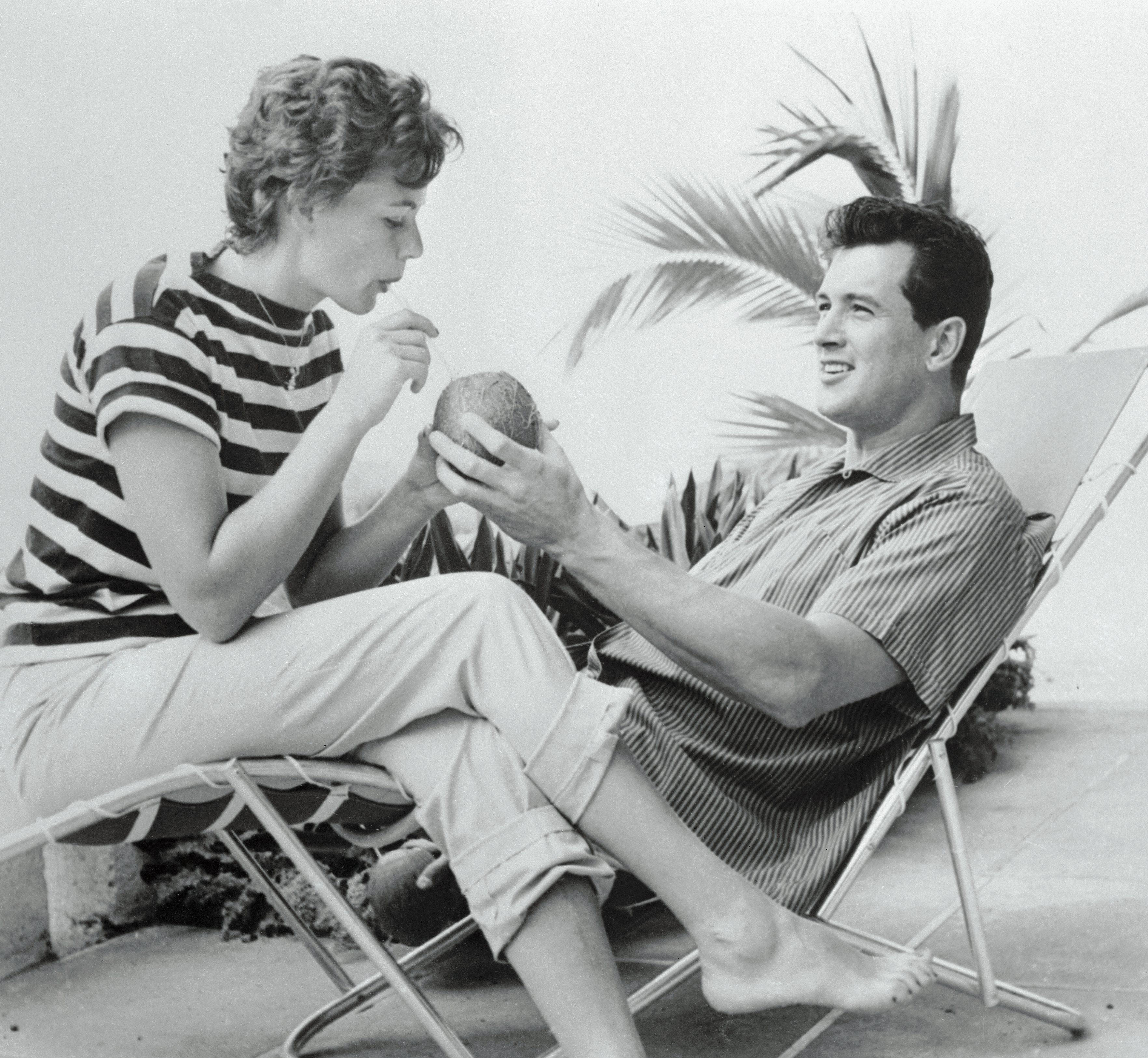 Rock Hudson and Phyllis Gates enjoying their coconut drinks while on their honeymoon in Jamaica | Source: Getty Images