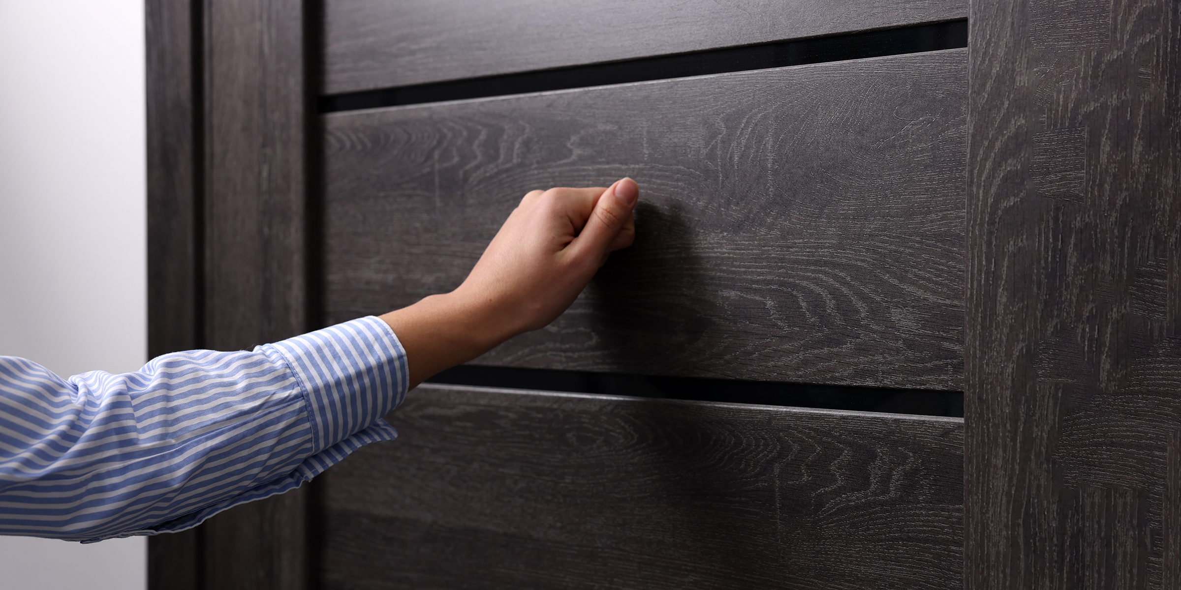 A woman knocking on a front door | Source: Shutterstock