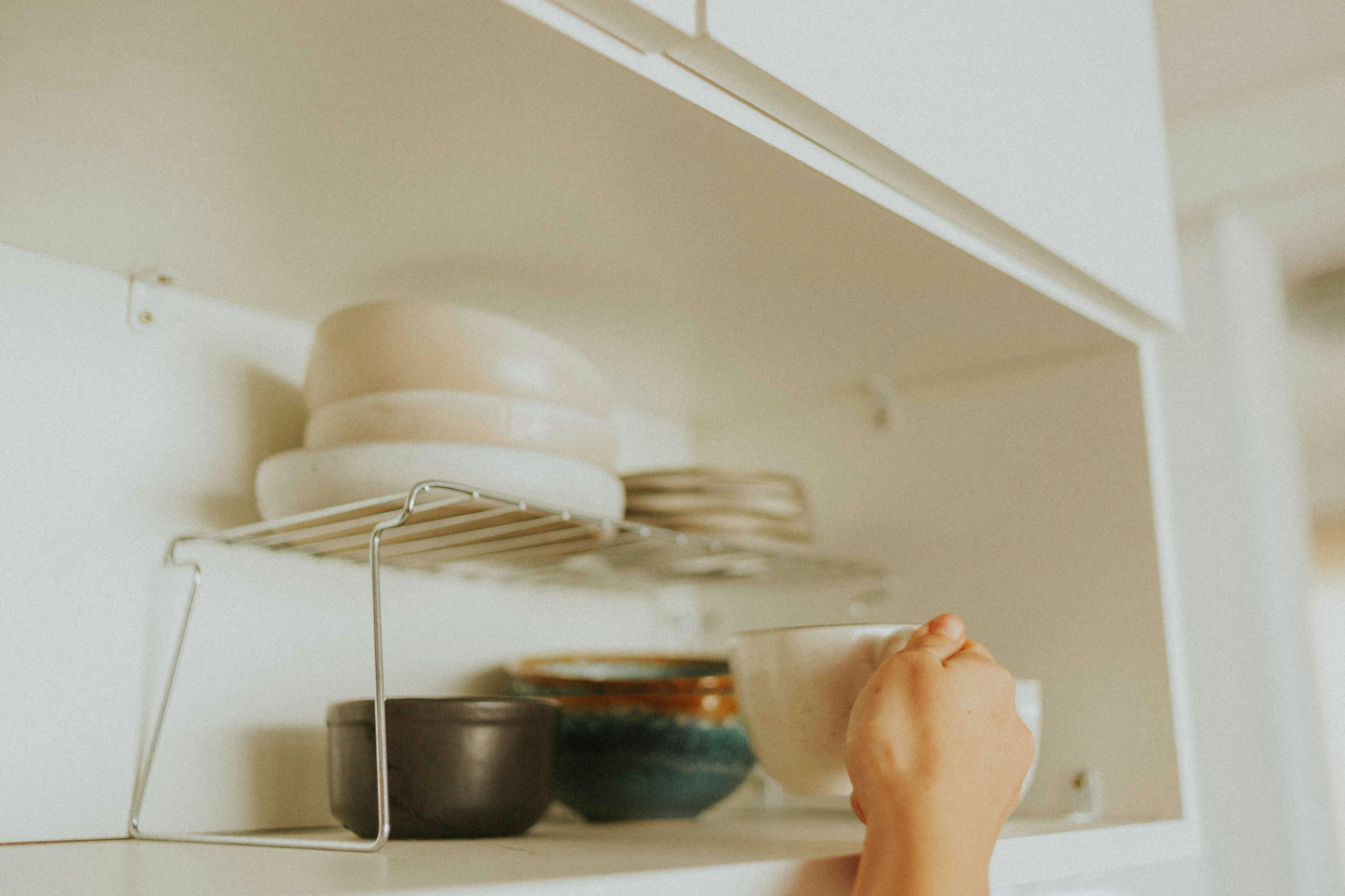 Organizing a kitchen cabinet | Source: Pexels
