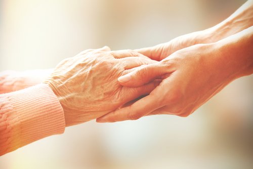 Ältere und jüngere Frau halten sich an den Händen | Quelle: Shutterstock