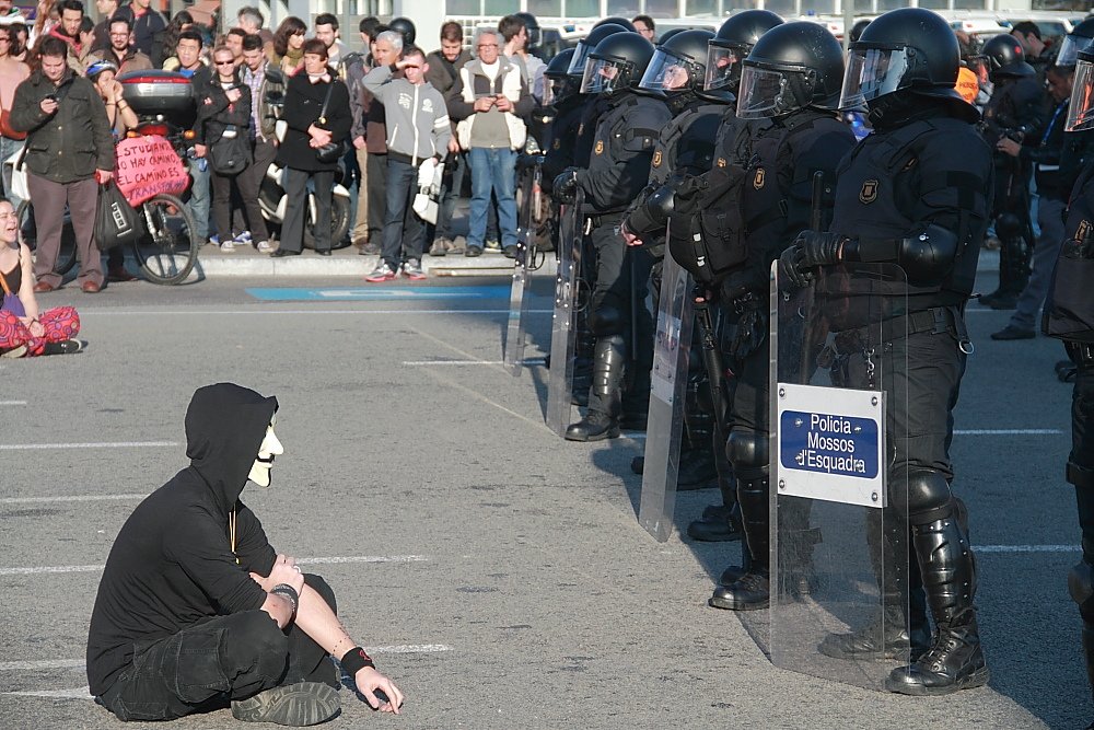 Represalías entre el cuerpo de policía de los Mossos d'Esquadra y un activista con máscara Anonymous.| Foto: Wikimedia Commons.