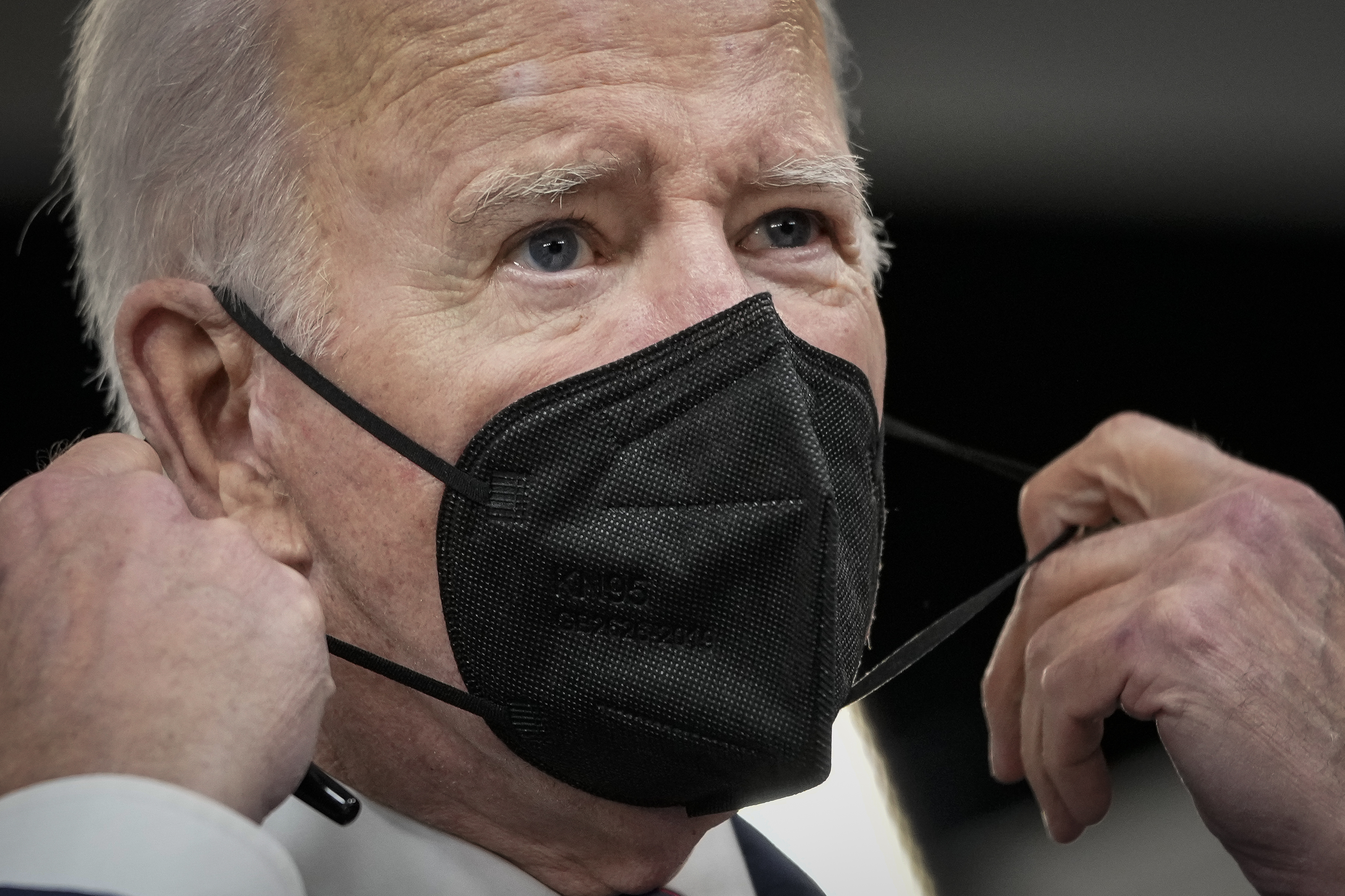 Joe Biden removes his face mask as he arrives in the South Court Auditorium of the White House complex on December 23, 2021 in Washington, DC | Source: Getty Images