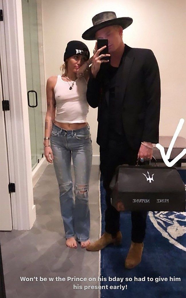 Miley Cyrus stands with Cody Simpson after she gifts him a vintage doctor's bag | Source: instagram.com/mileycyrus
