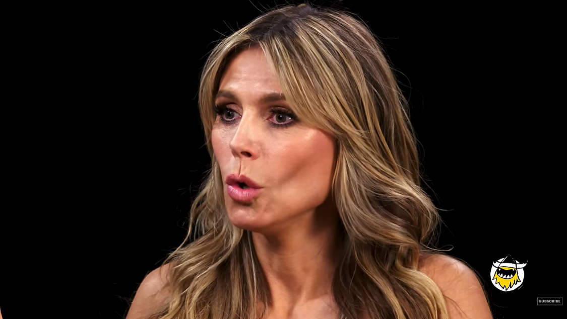Heidi Klum reacts to the spice of the chicken wing in the "Hot Ones" episode on the First We Feast YouTube channel in June 2024. | Source: YouTube/FirstWeFeast