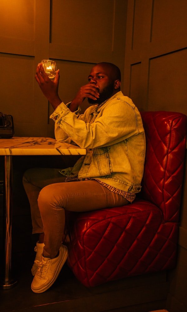 A man staring at his glass of drink. | Photo: Unsplash/Tobias Nii Kwatei Quartey