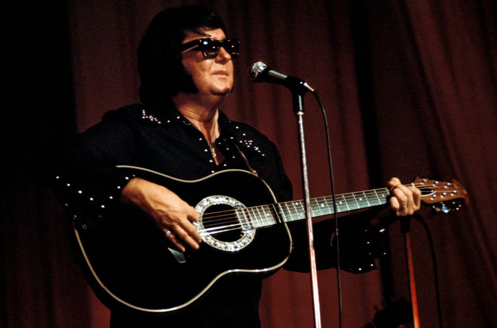 Roy Orbison performs live on stage playing an Ovation acoustic guitar during the Pop Proms at Belle Vue in Manchester, England in 1975. | Source: Getty Images