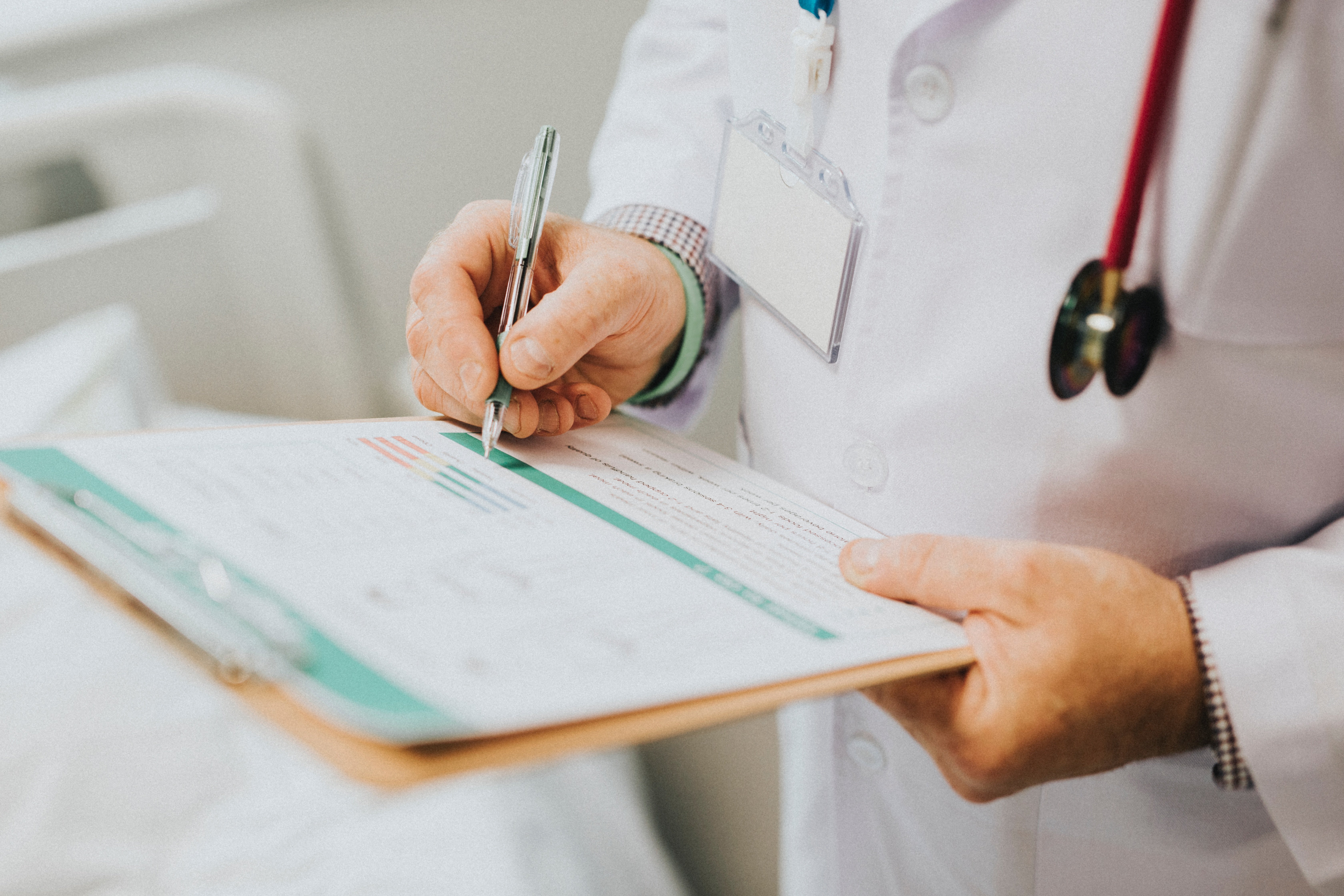 Un Docteur écrivant sur papier | Source : Unsplash Un Docteur écrivant sur papier | Source : Unsplash