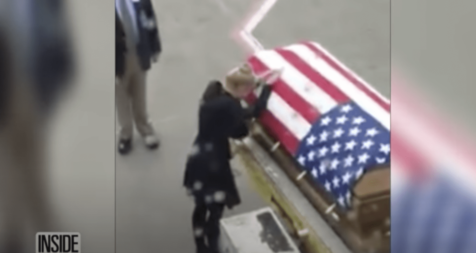 Tara Thomas places both her hands on the flag-draped coffin and breaks down. | Source: YouTube.com/Inside Edition