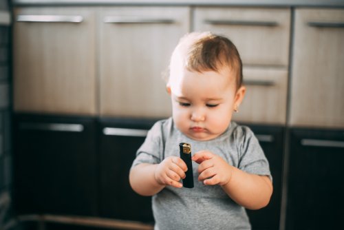 Baby tries to light black lighter.| Photo: Shutterstock.