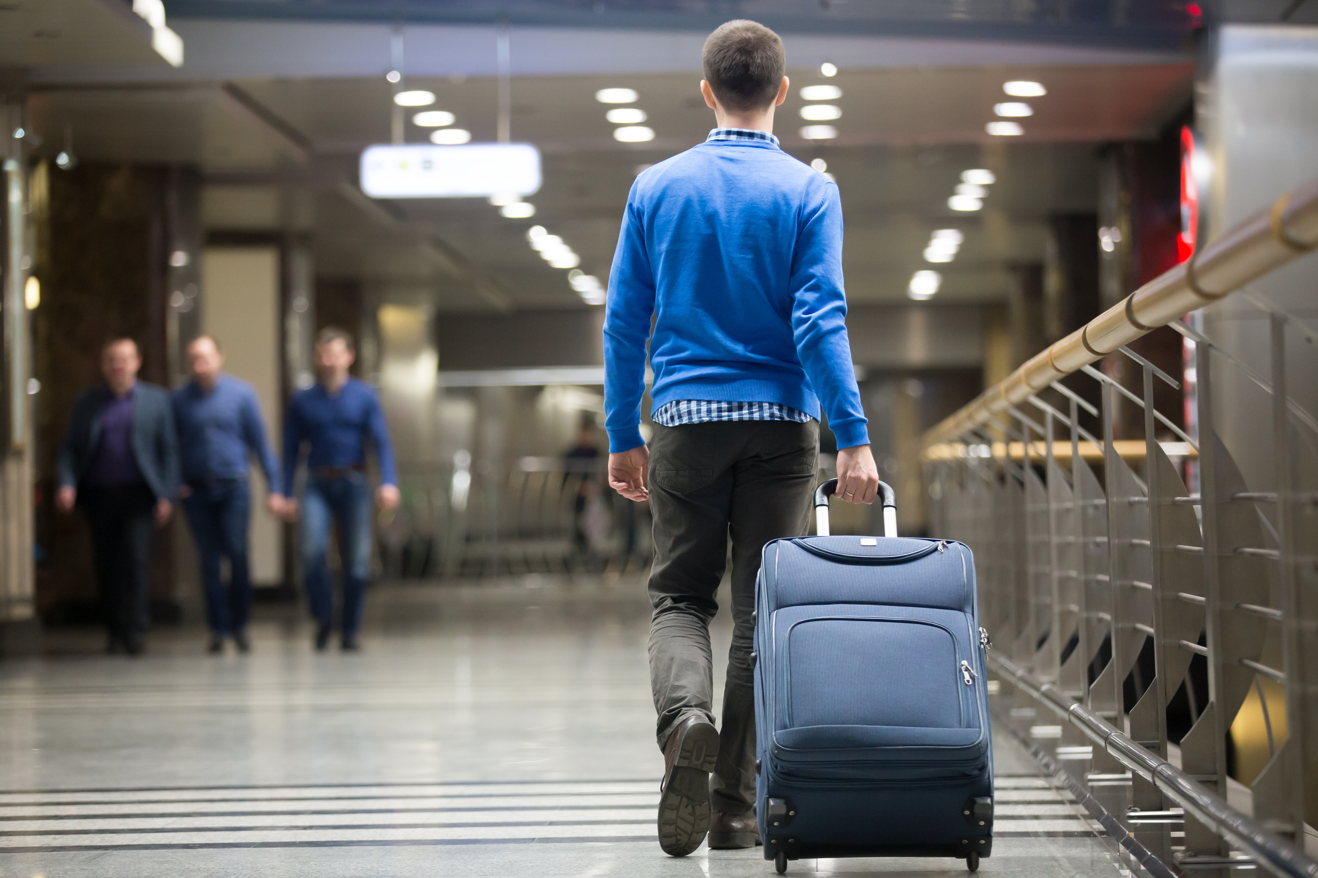 Man walking with his luggage in an airport | Source: Shutterstock