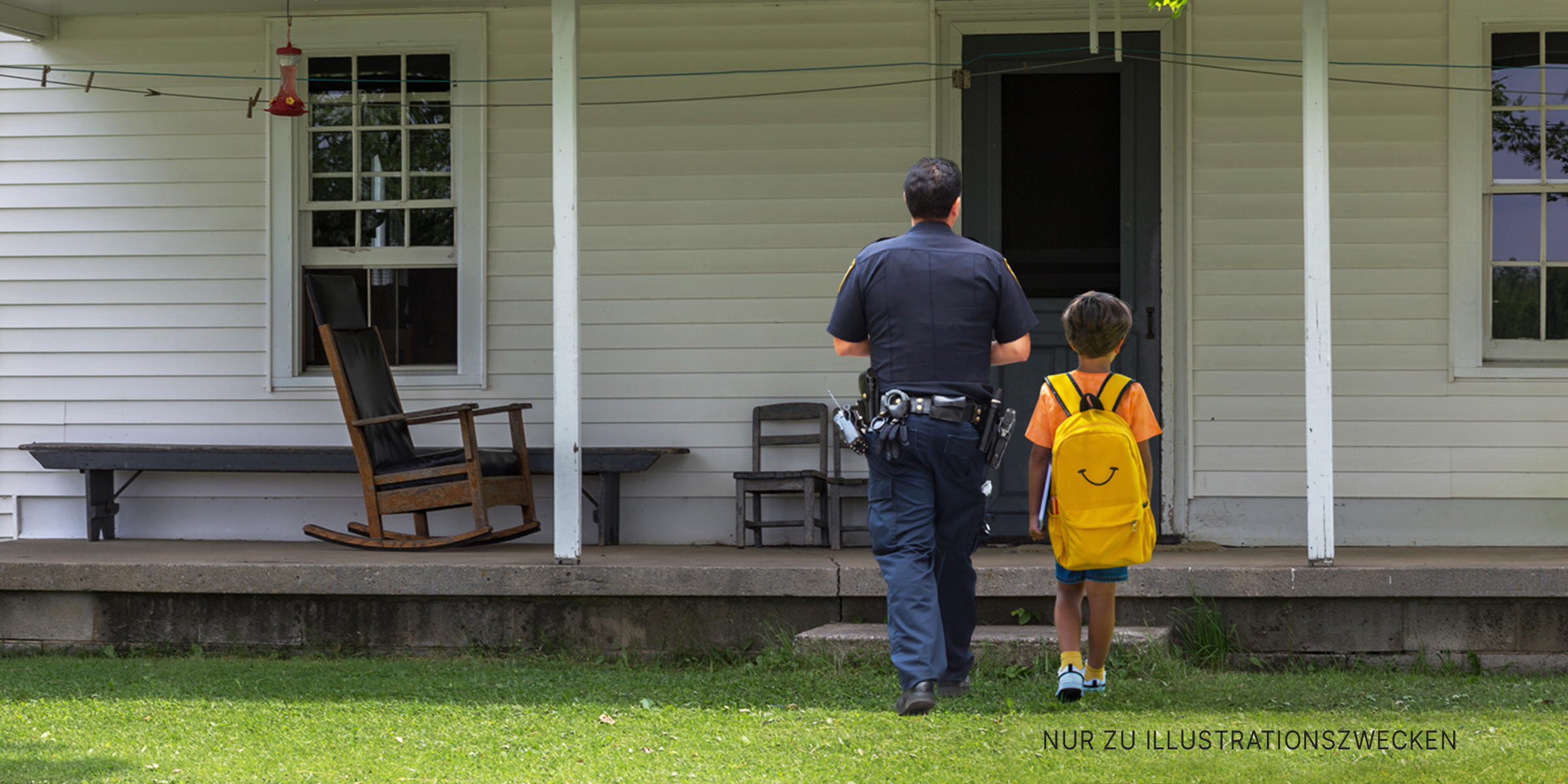 Kleiner Junge und Polizist gehen auf ein Haus zu | Quelle: Shutterstock