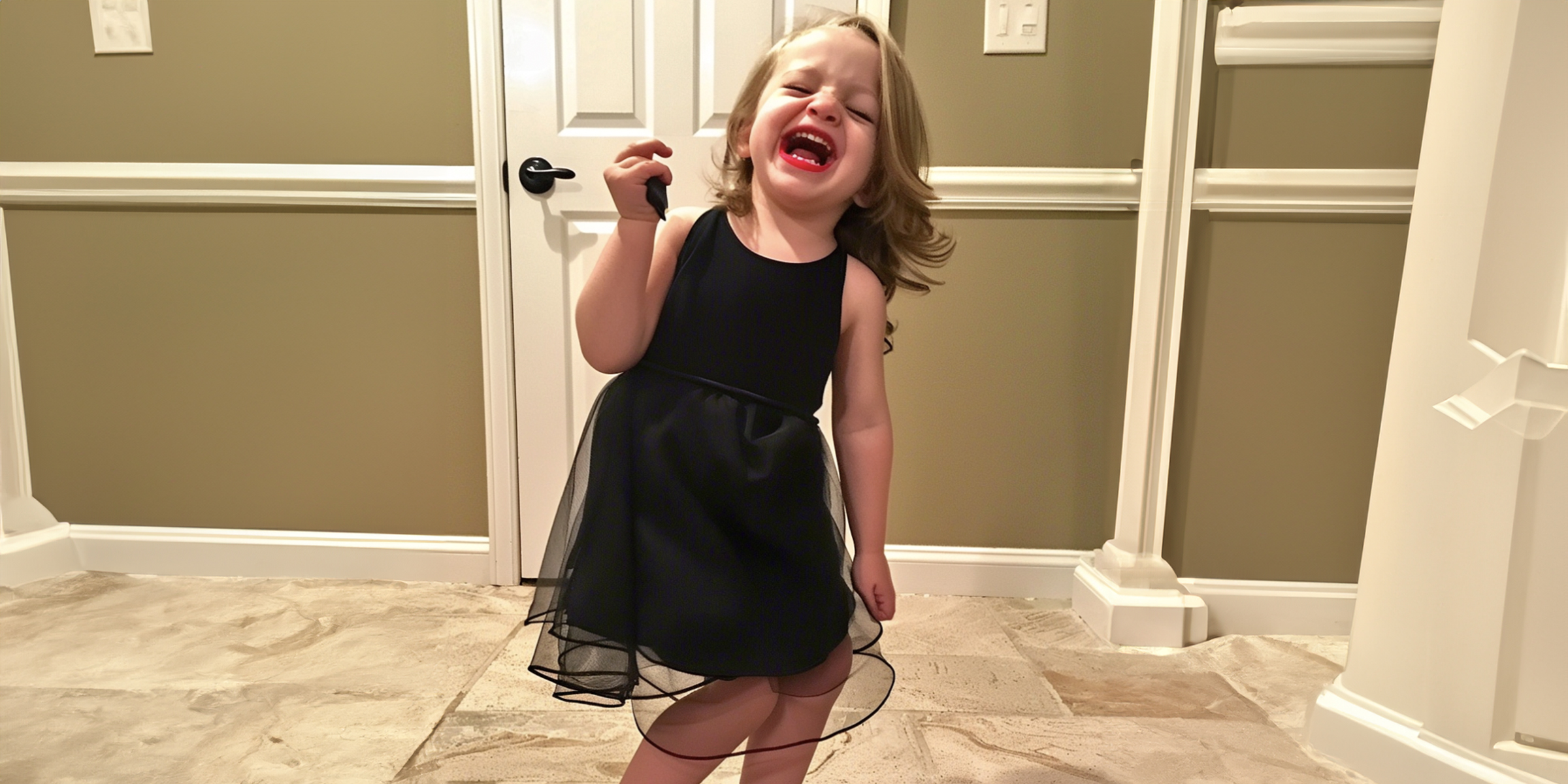 A little girl wearing a black dress and red lipstick | Source: Amomama