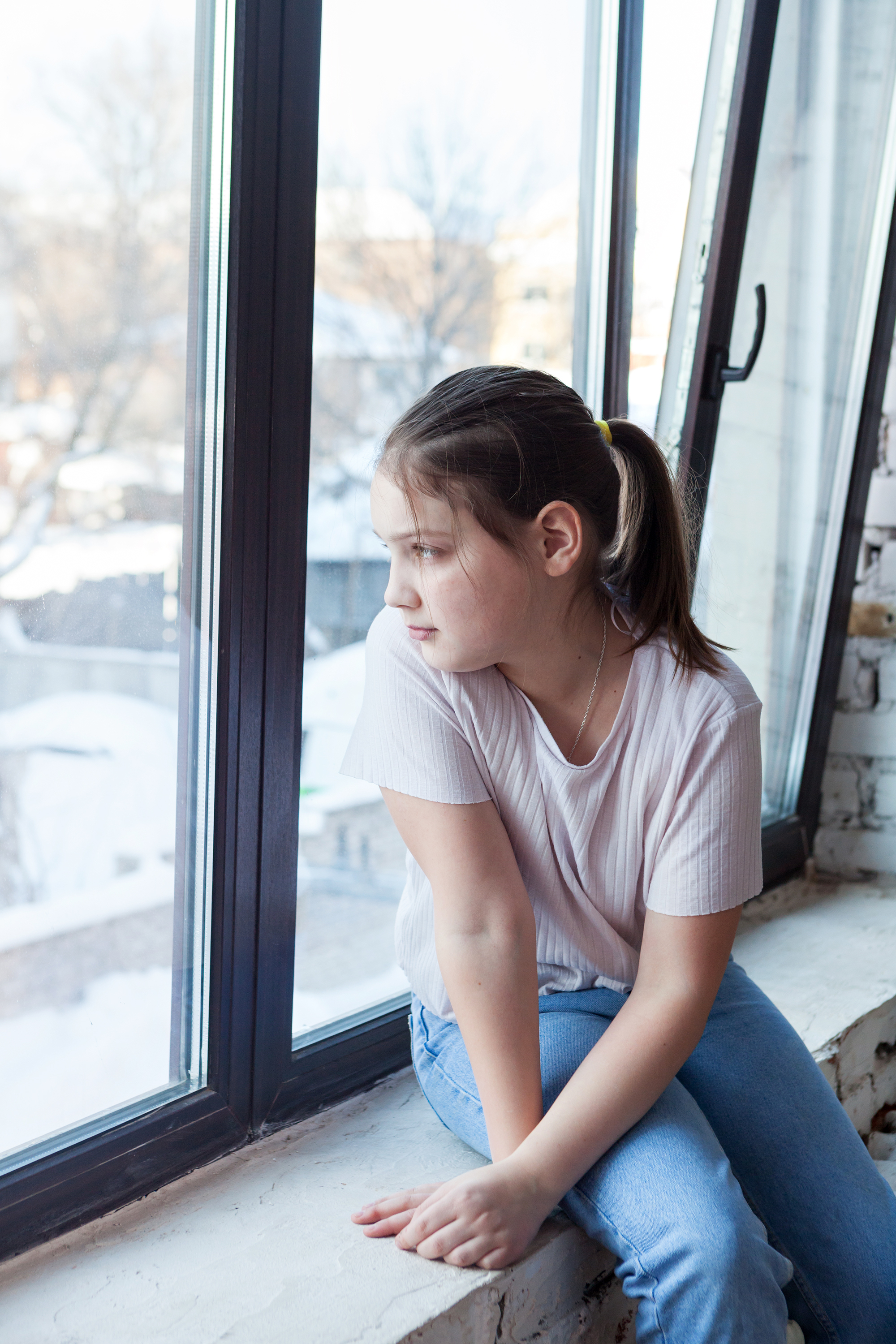 Young girl looking out the window | Source: Shutterstock