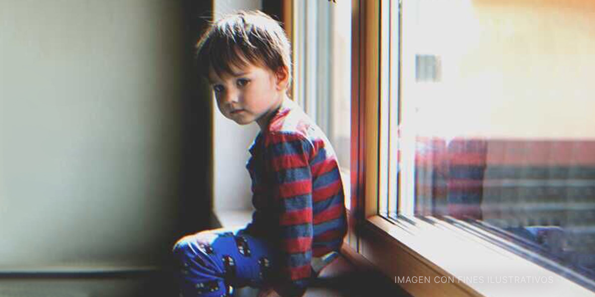 Niño sentando en una ventana. | Foto: Shutterstock