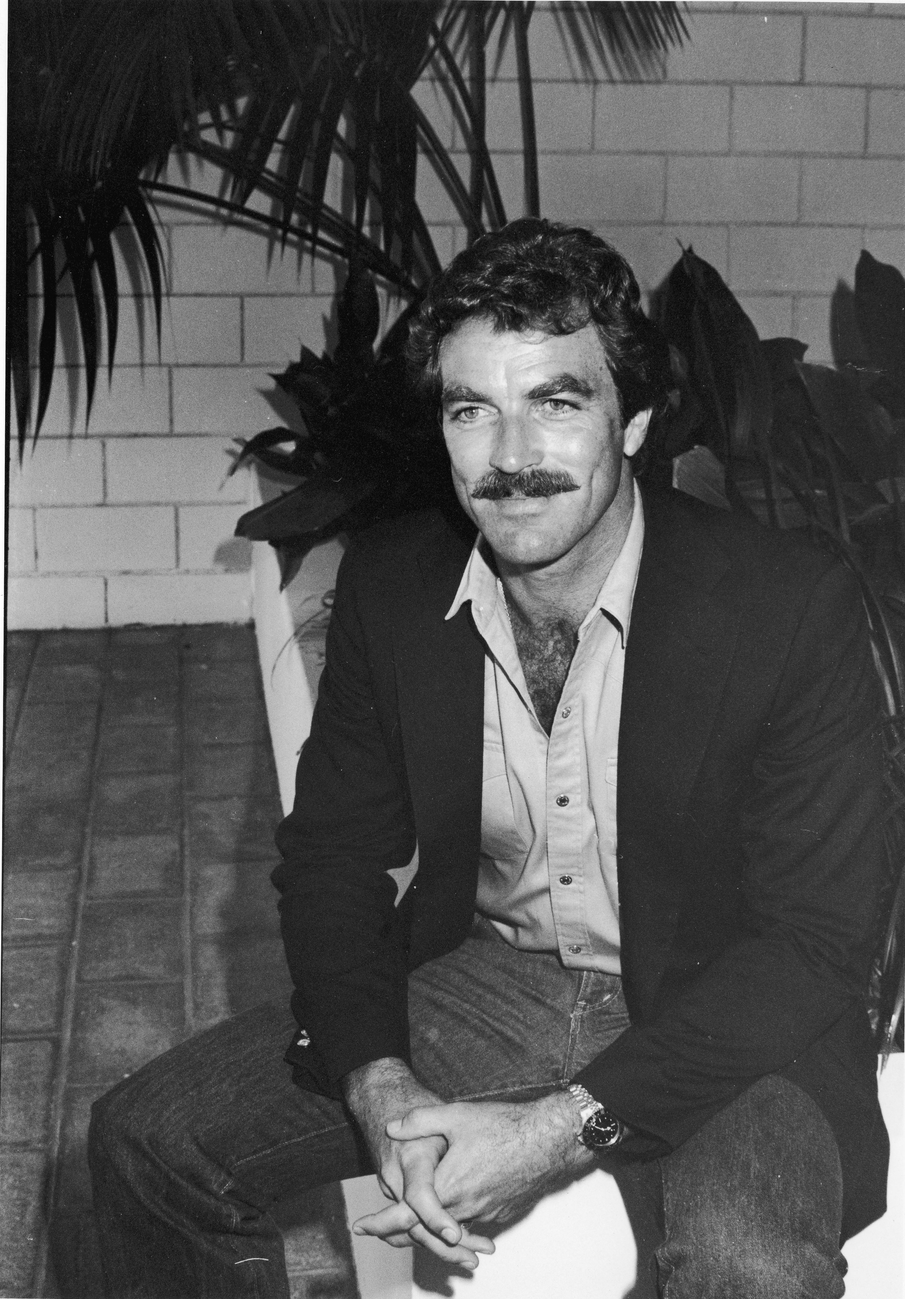 Tom Selleck sitzt auf einer Terrasse während eines Brunchs im Beverly Hilton Hotel, Beverly Hills, Kalifornien, Juli 1981. | Quelle: Getty Images