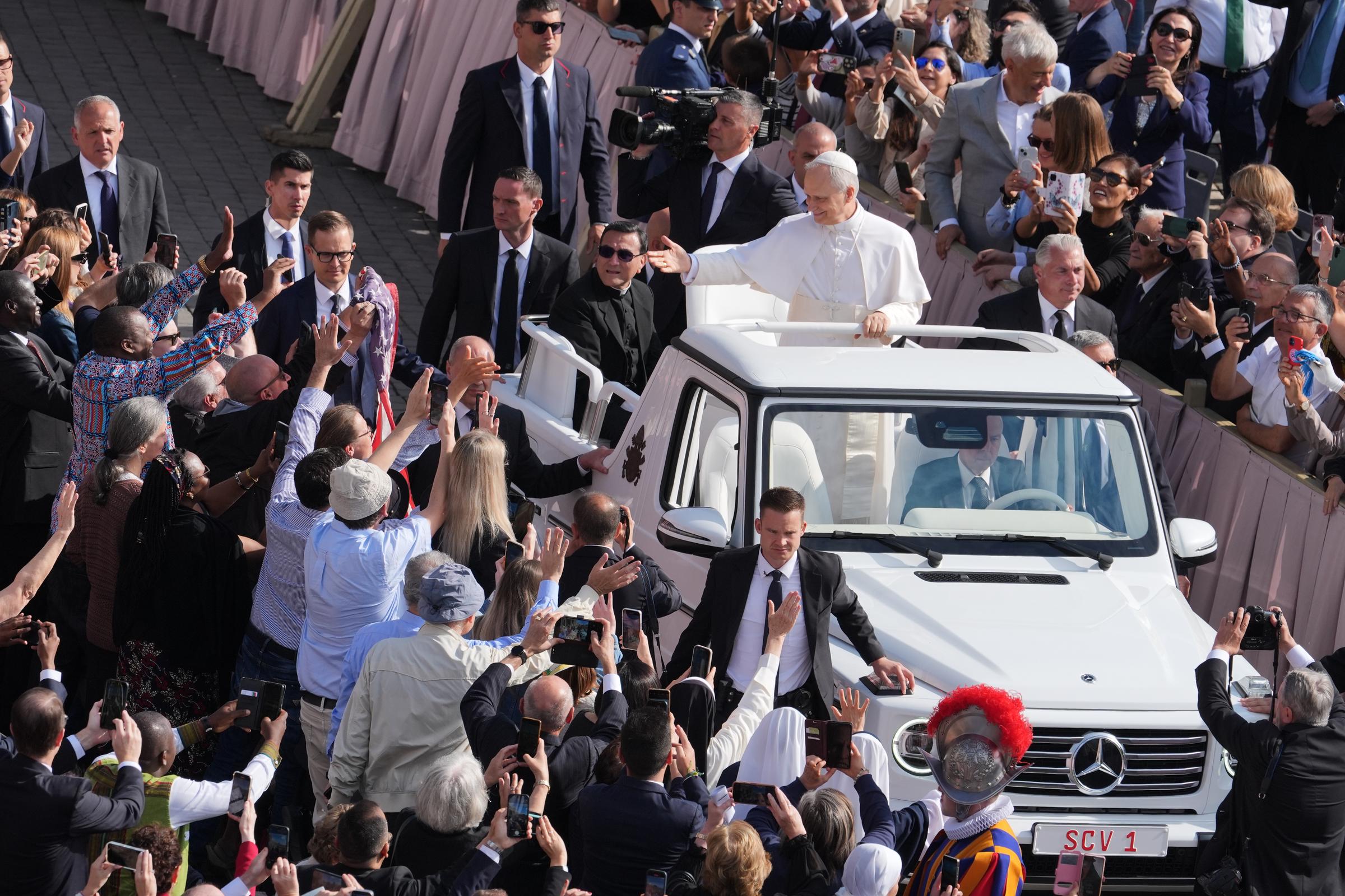 Pope Leo XIV waves to a cheering crowd as he rides through St. Peter's Square in an open-back Popemobile during his Inauguration Mass on May 18, 2025. | Source: Getty Images