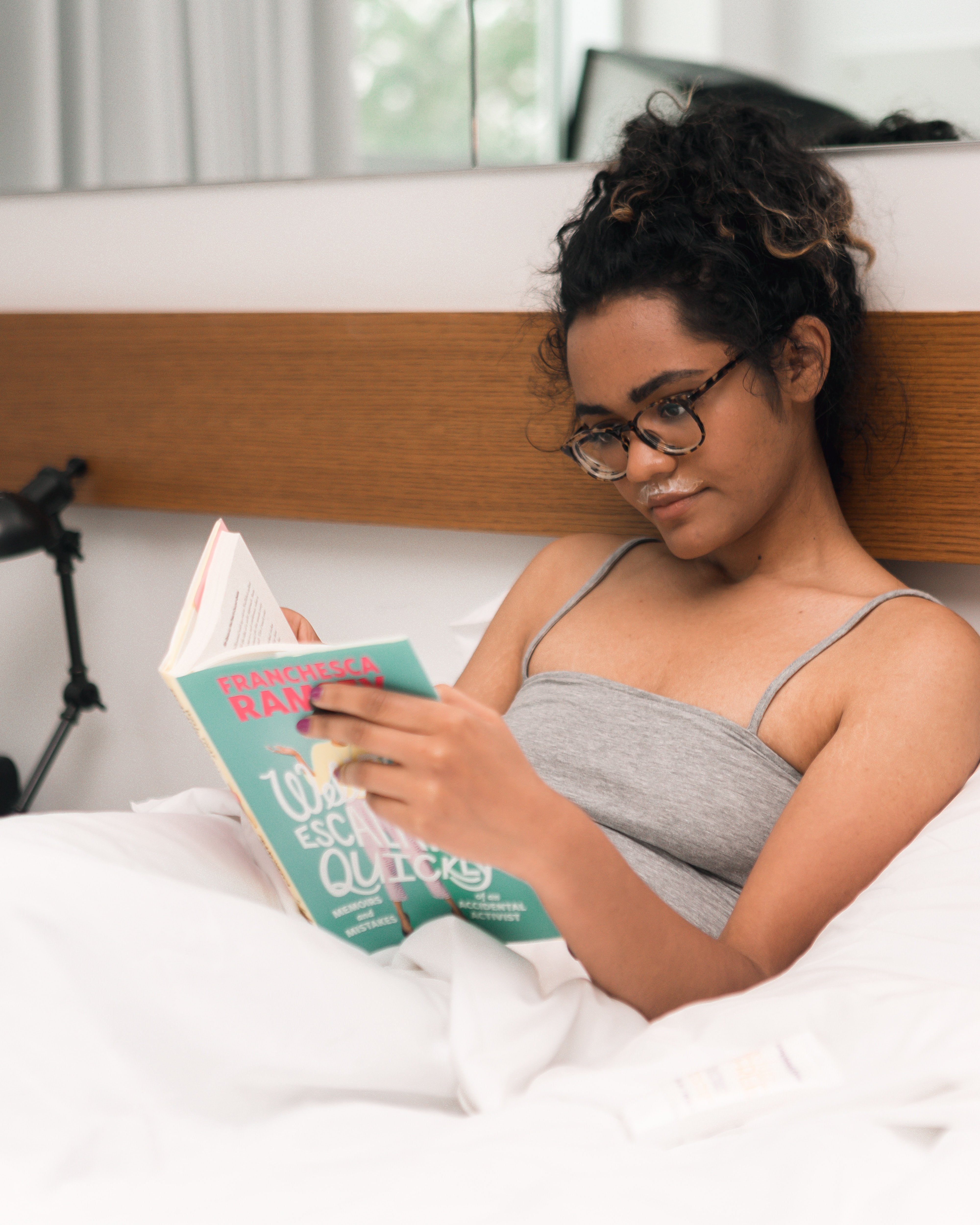 A woman reading a book in bed | Source: Unsplash.com
