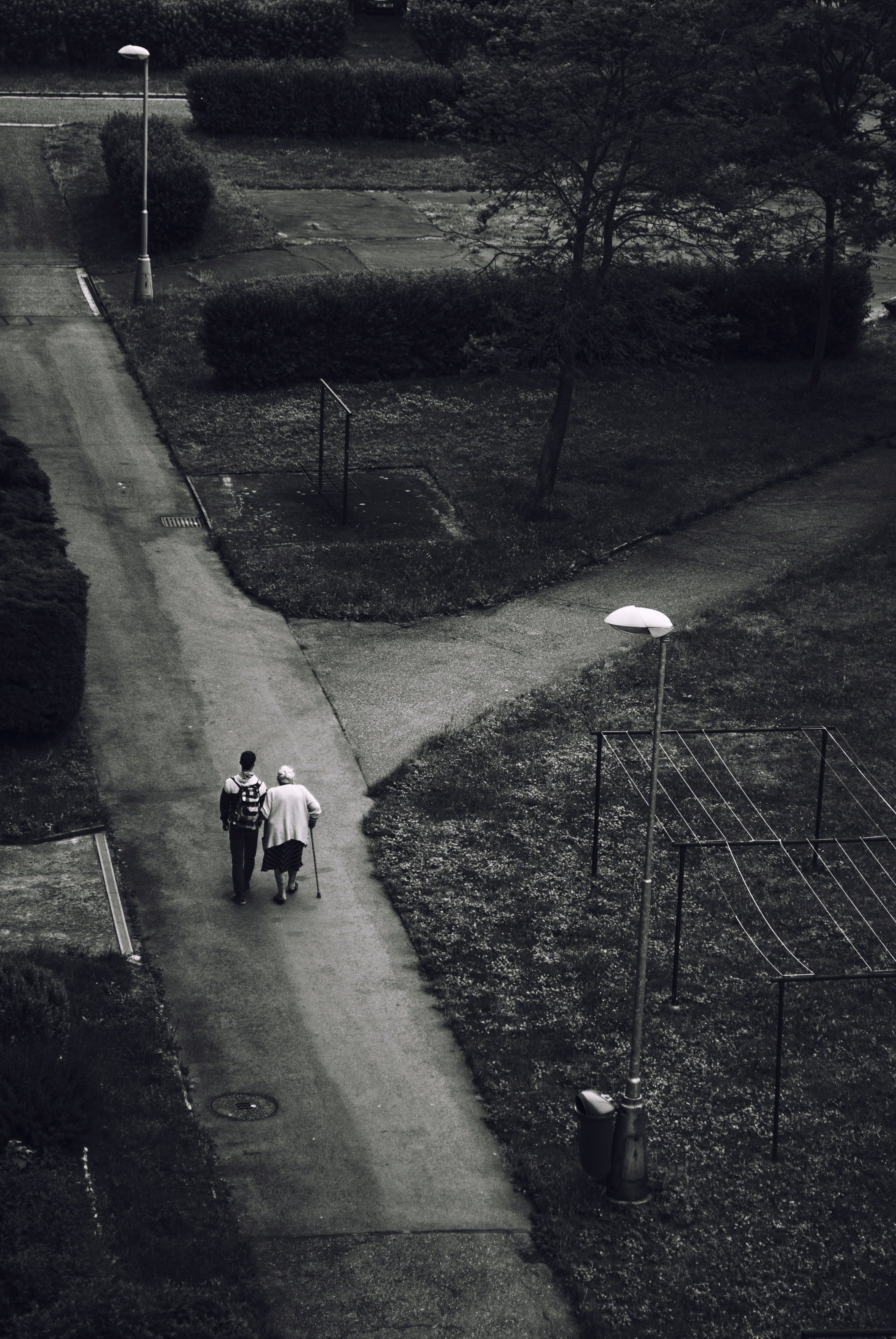 Hombre llevando del brazo a una anciana con bastón. | Foto: Pexels