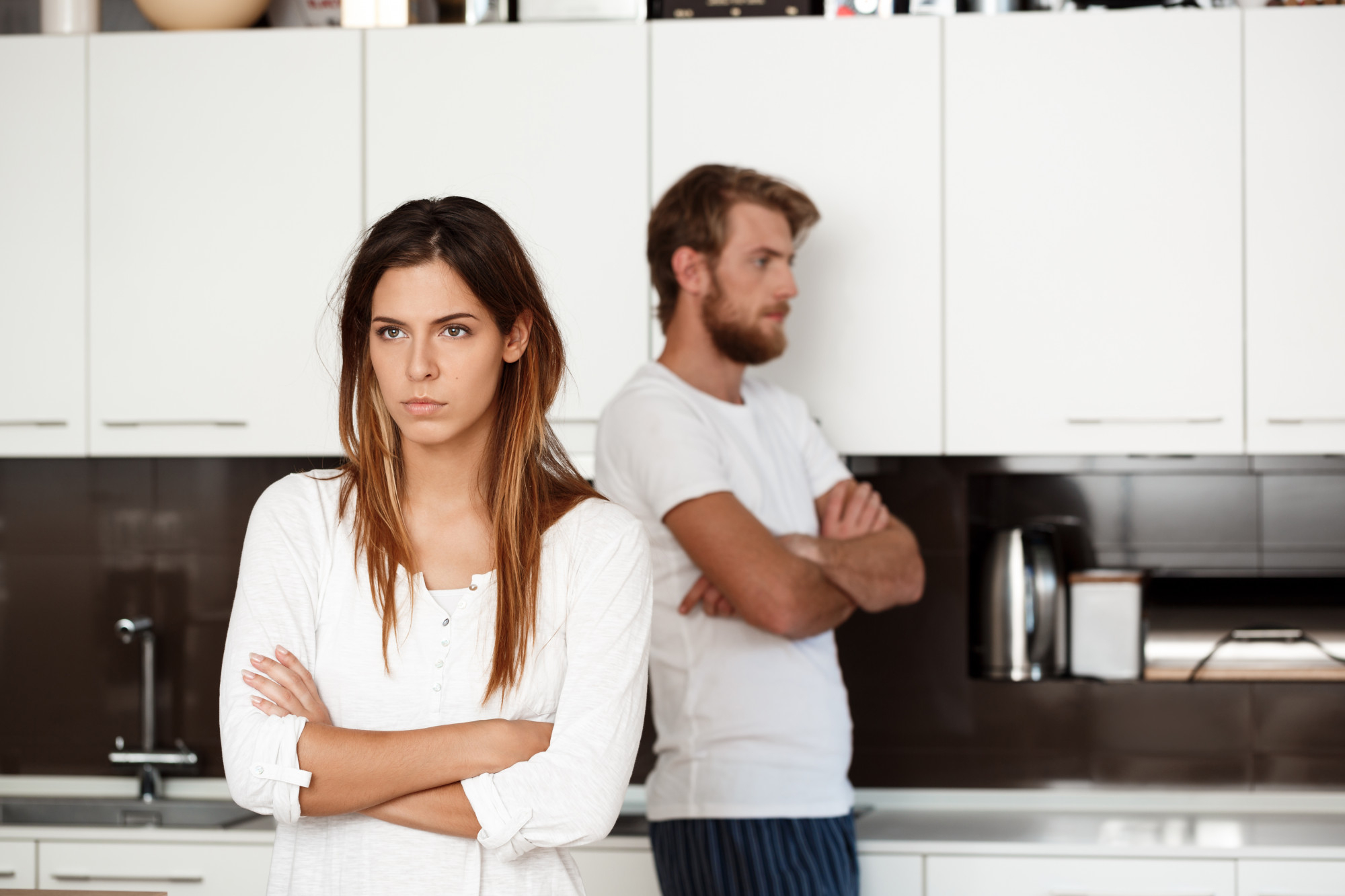 A couple giving each other the cold shoulder in the kitchen | Source: Freepik