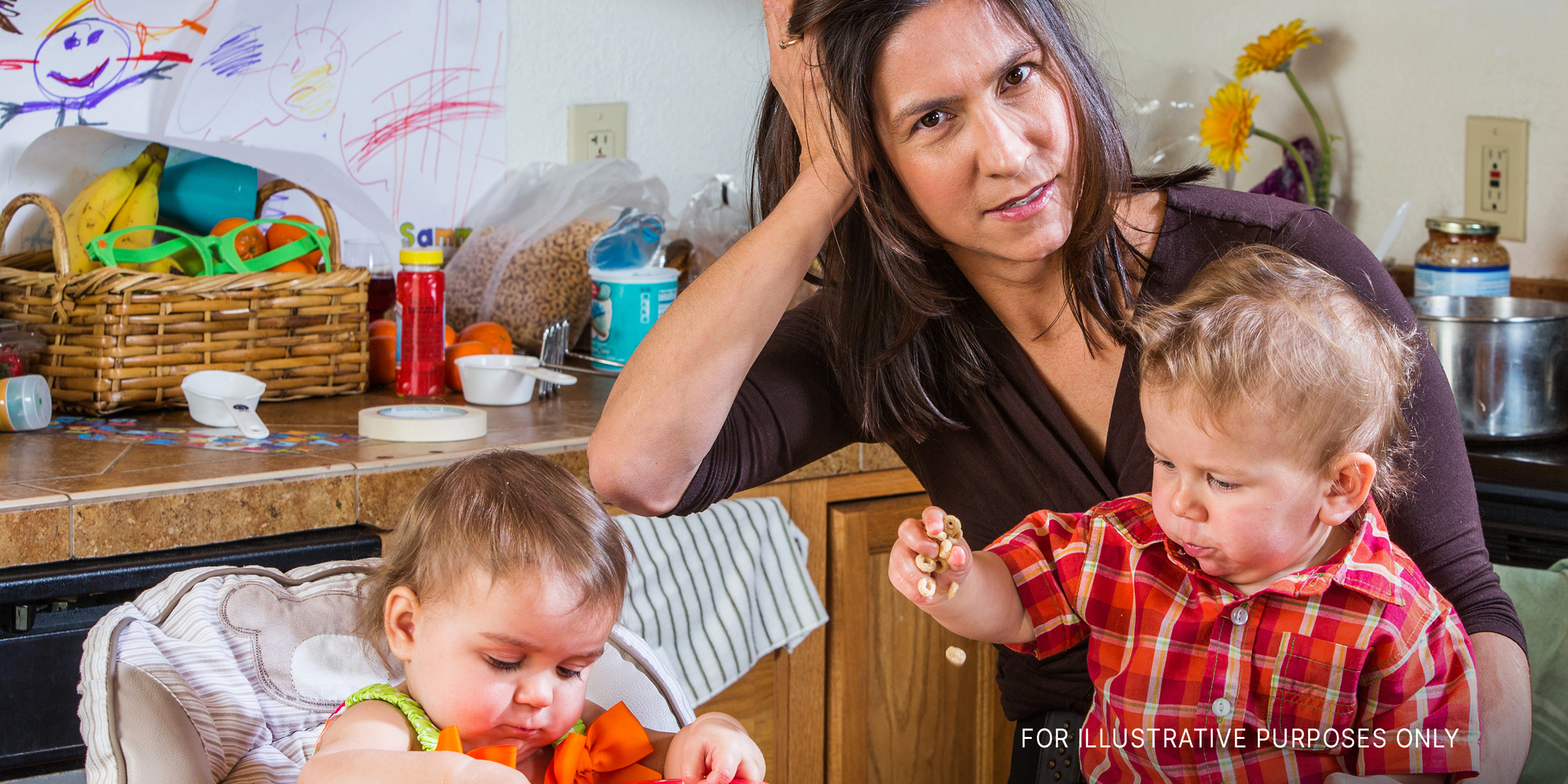 A stressed-out mother in the kitchen with her babies | Source: Shutterstock