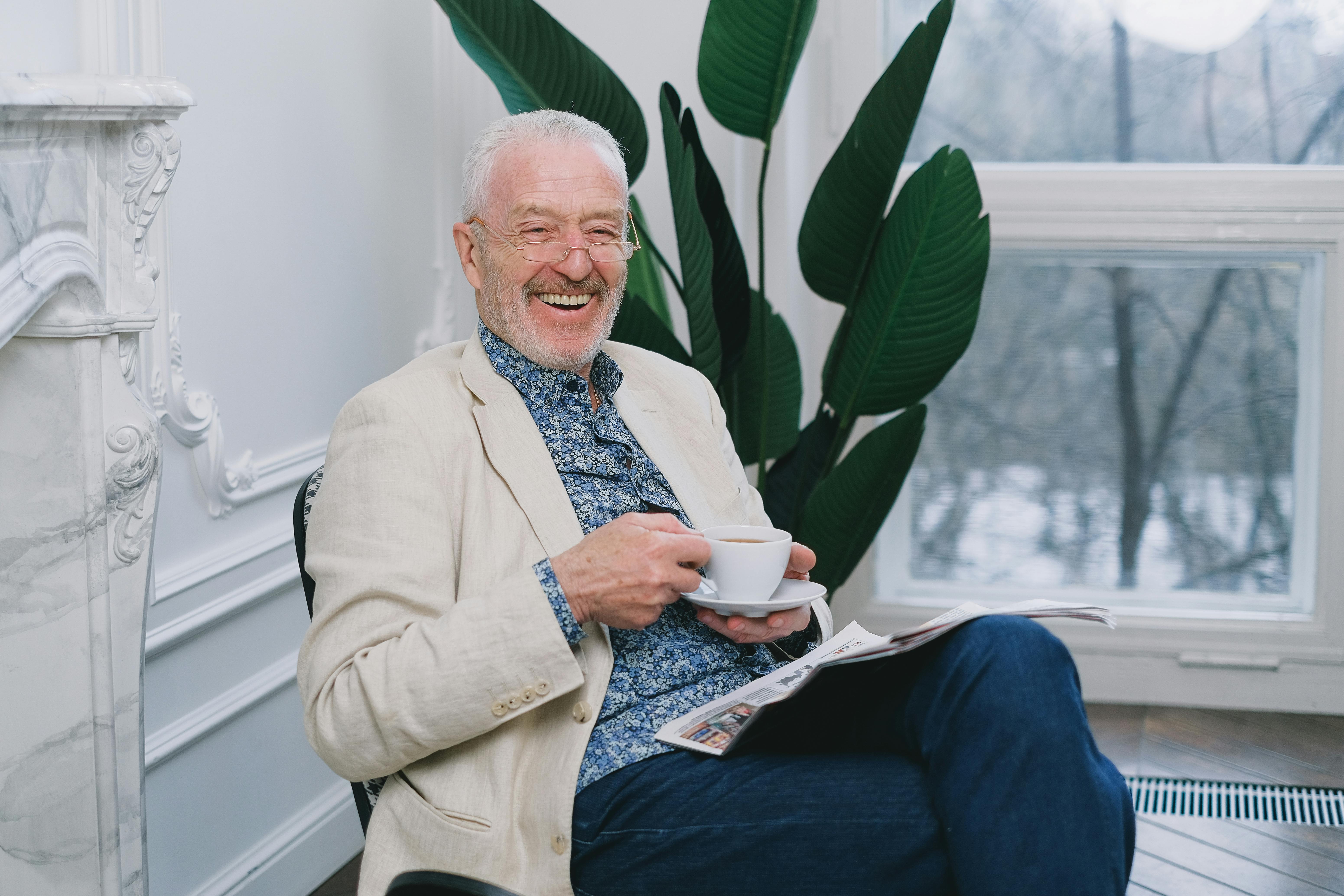 A happy man holding a cup of tea | Source: Pexels