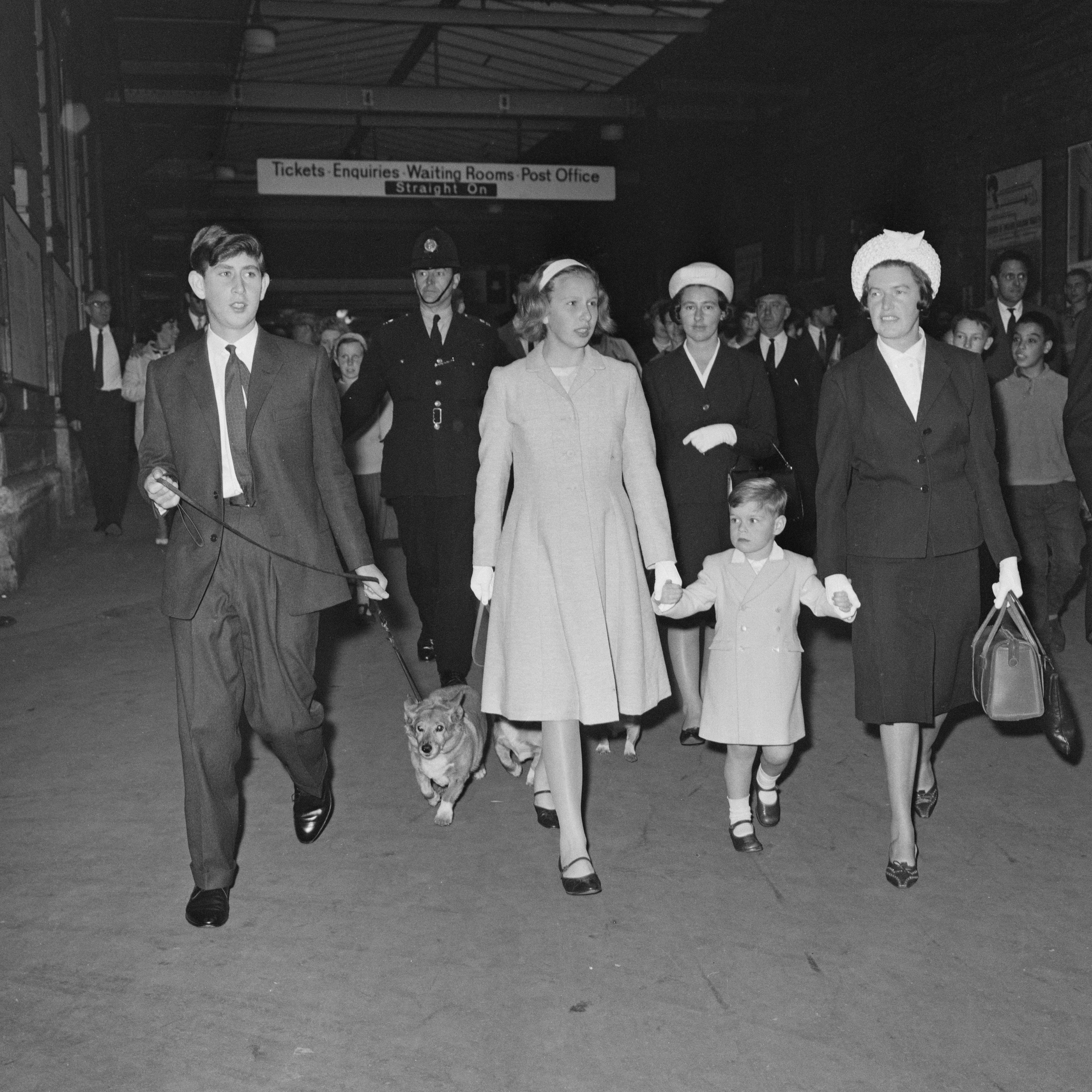 Prince Charles, walking a Corgi, Princess Anne, Prince Andrew, and their nanny Mabel Anderson at Euston Station, London, on August 8, 1963 | Source: Getty Images