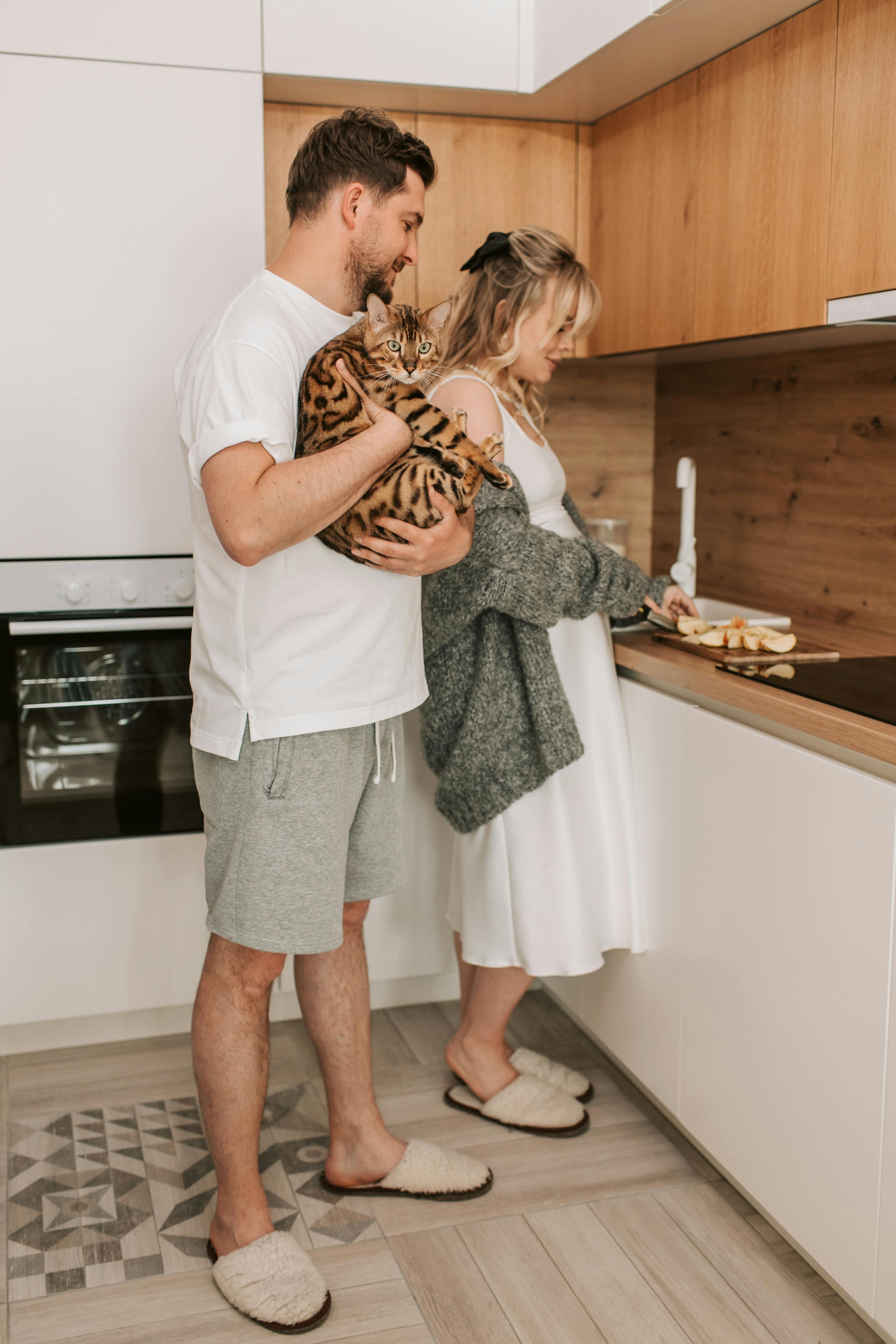 A couple in the kitchen with their cat | Source: pexels