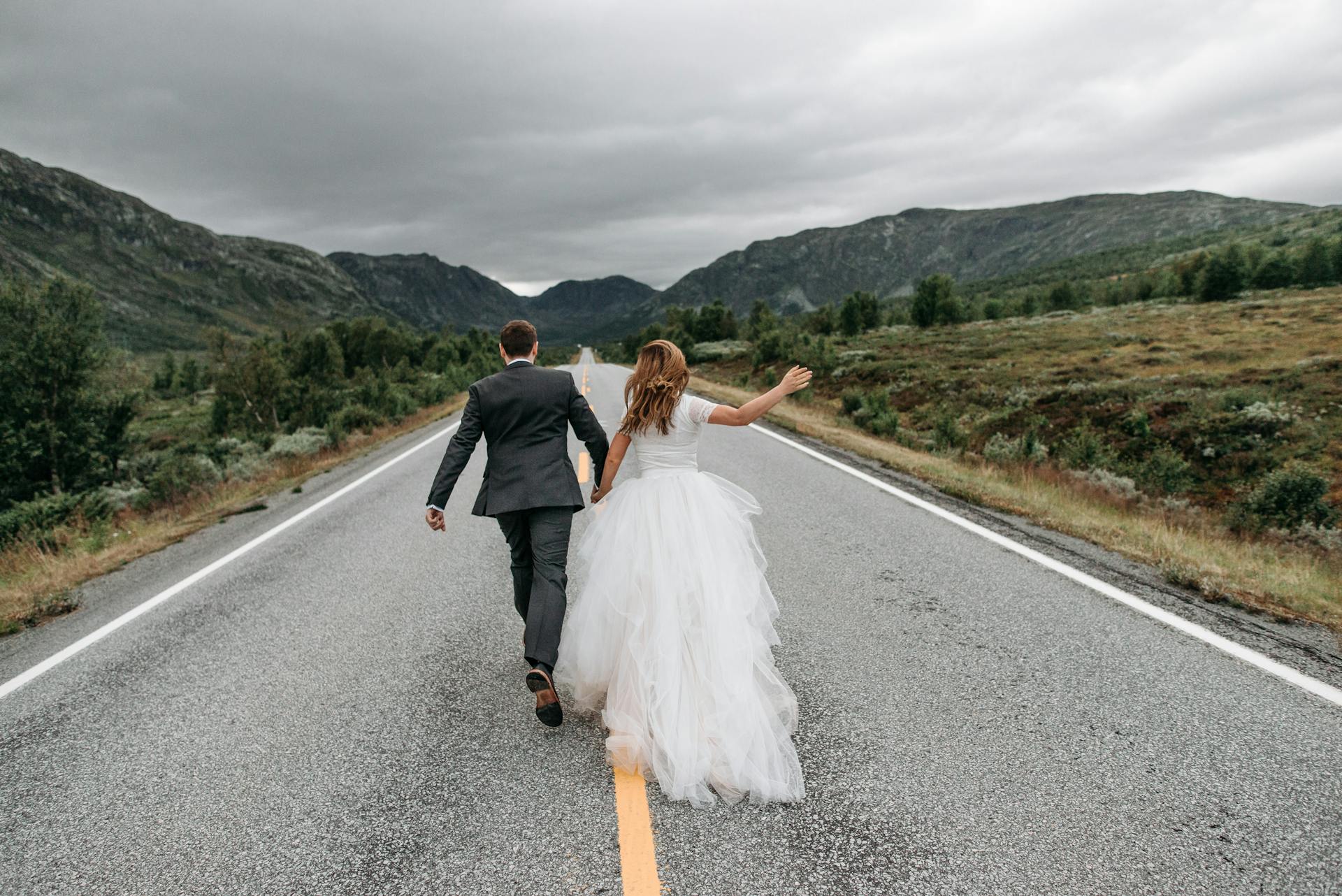 A bride and groom running on a road | Source: Pexels