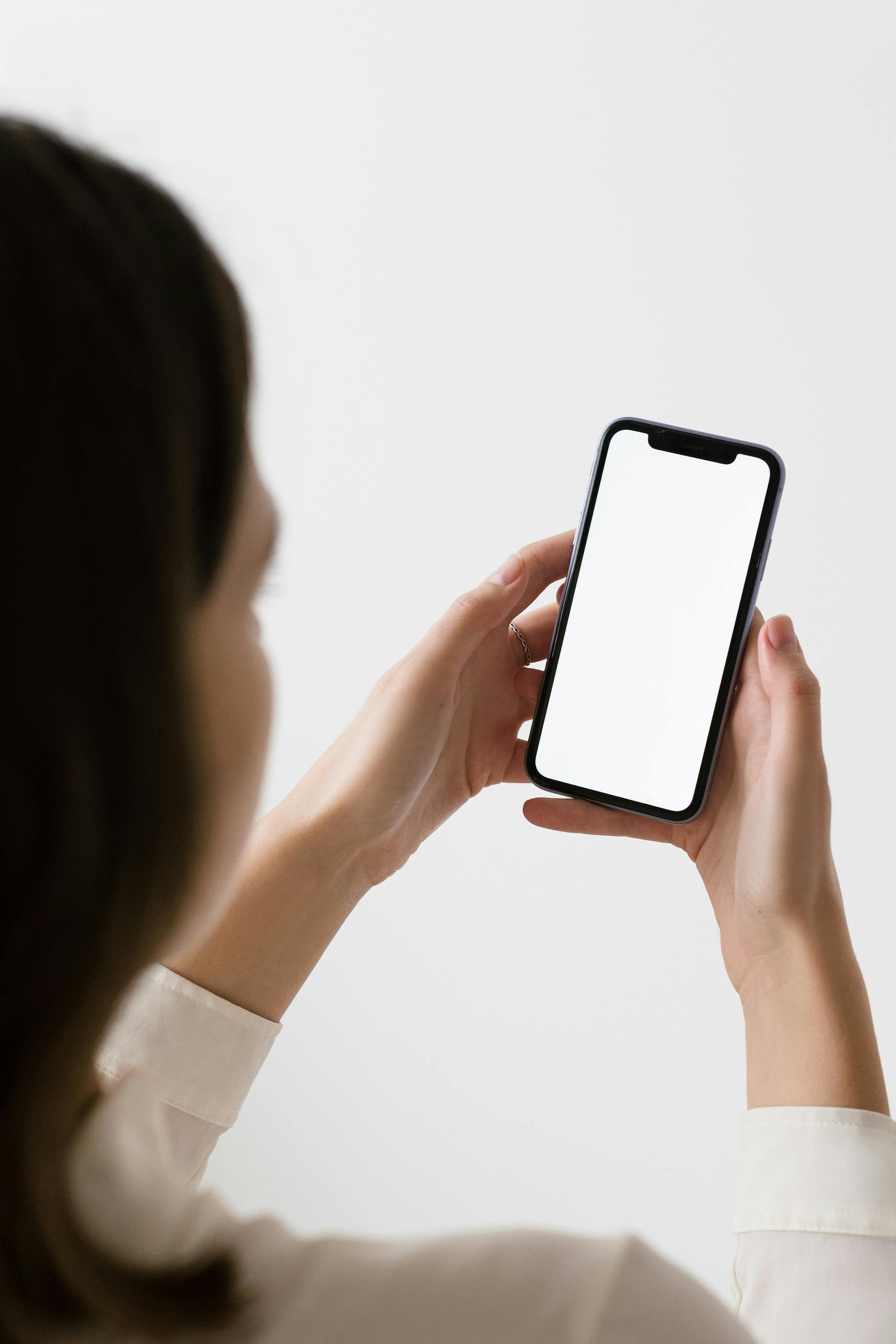 Rear view of a woman holding her smartphone | Source: Pexels