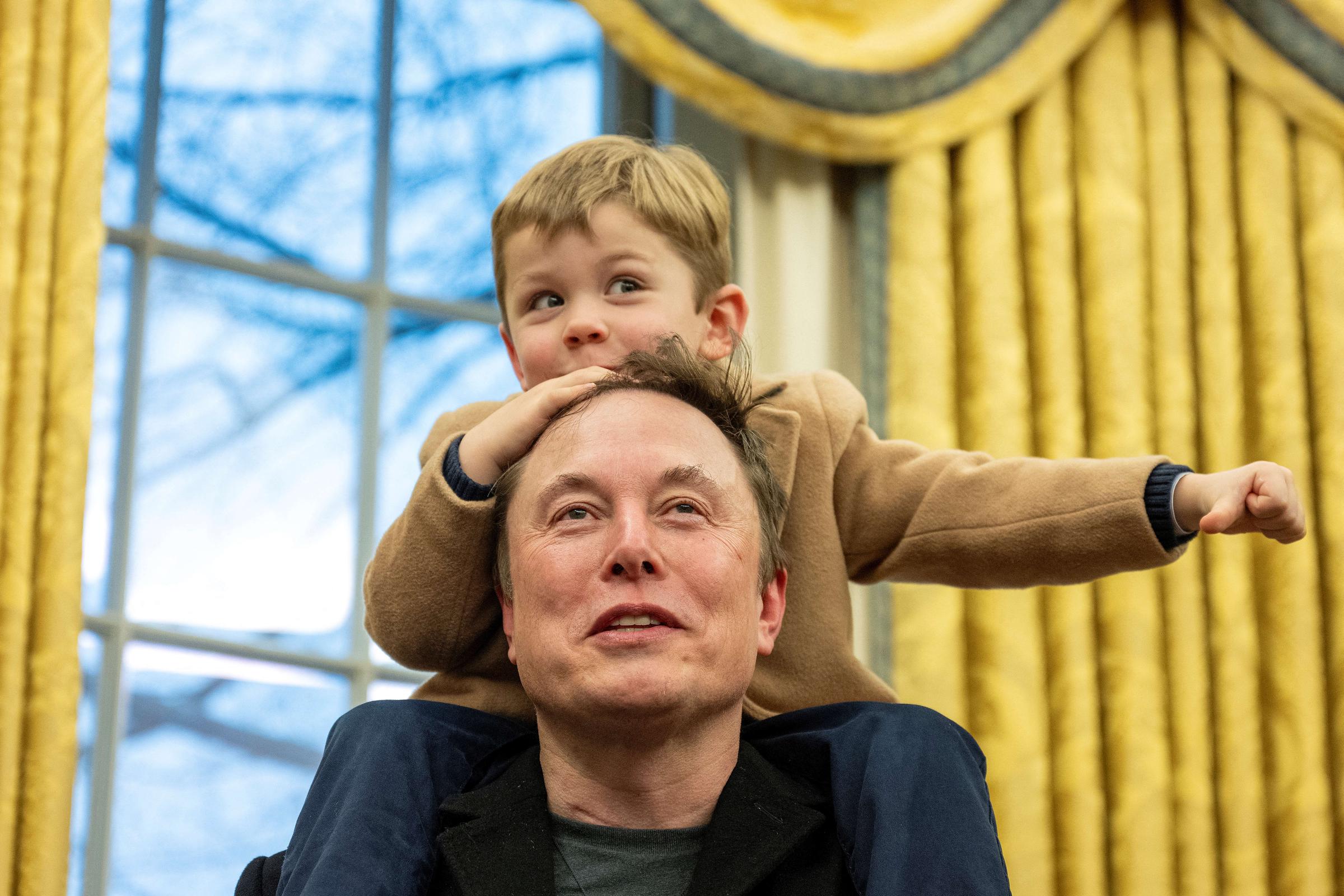 Elon Musk carries his son X Æ A-Xii on his shoulders while speaking in the Oval Office. | Source: Getty Images