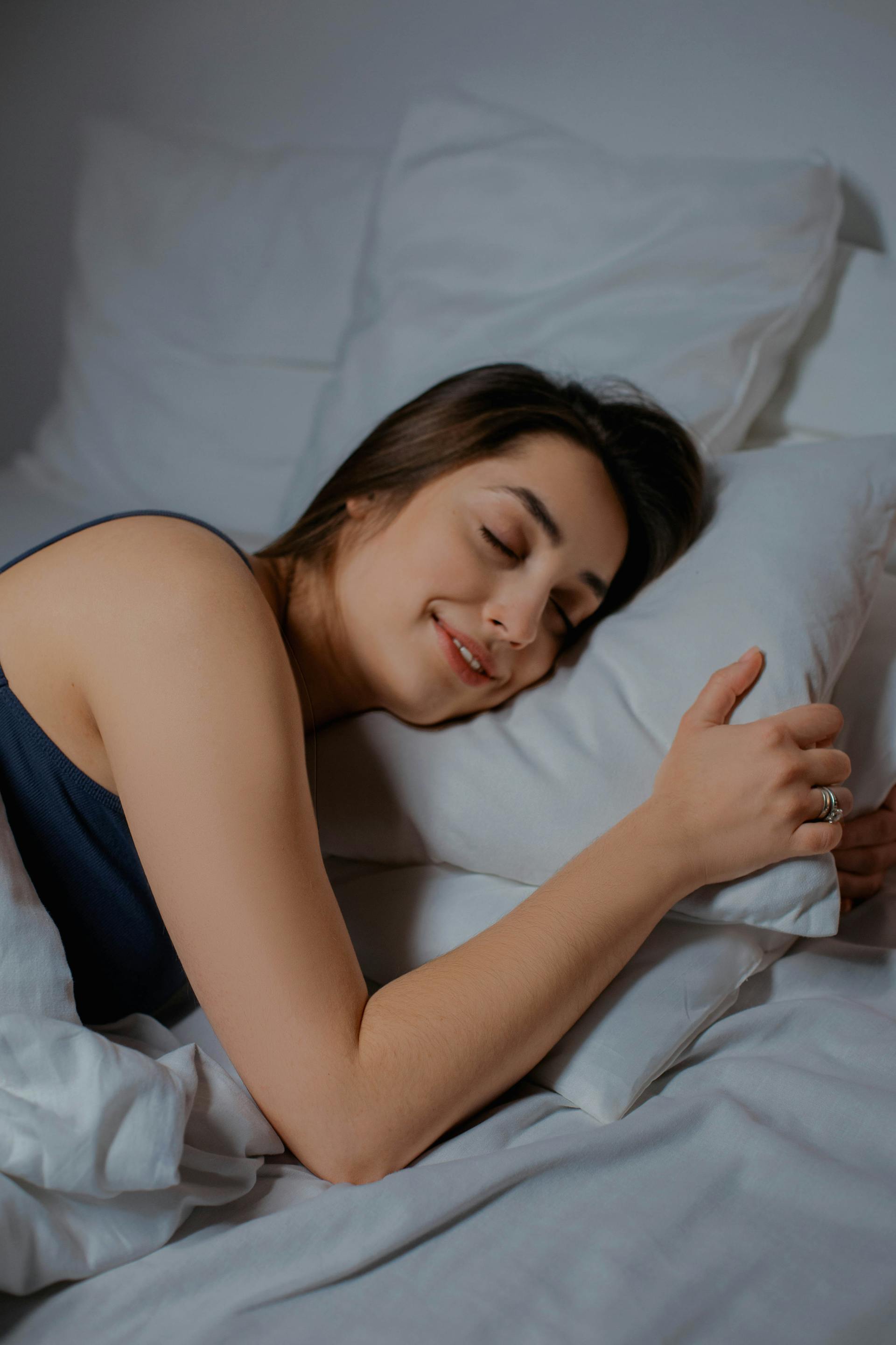 A woman lying in bed with her eyes closed | Source: Pexels