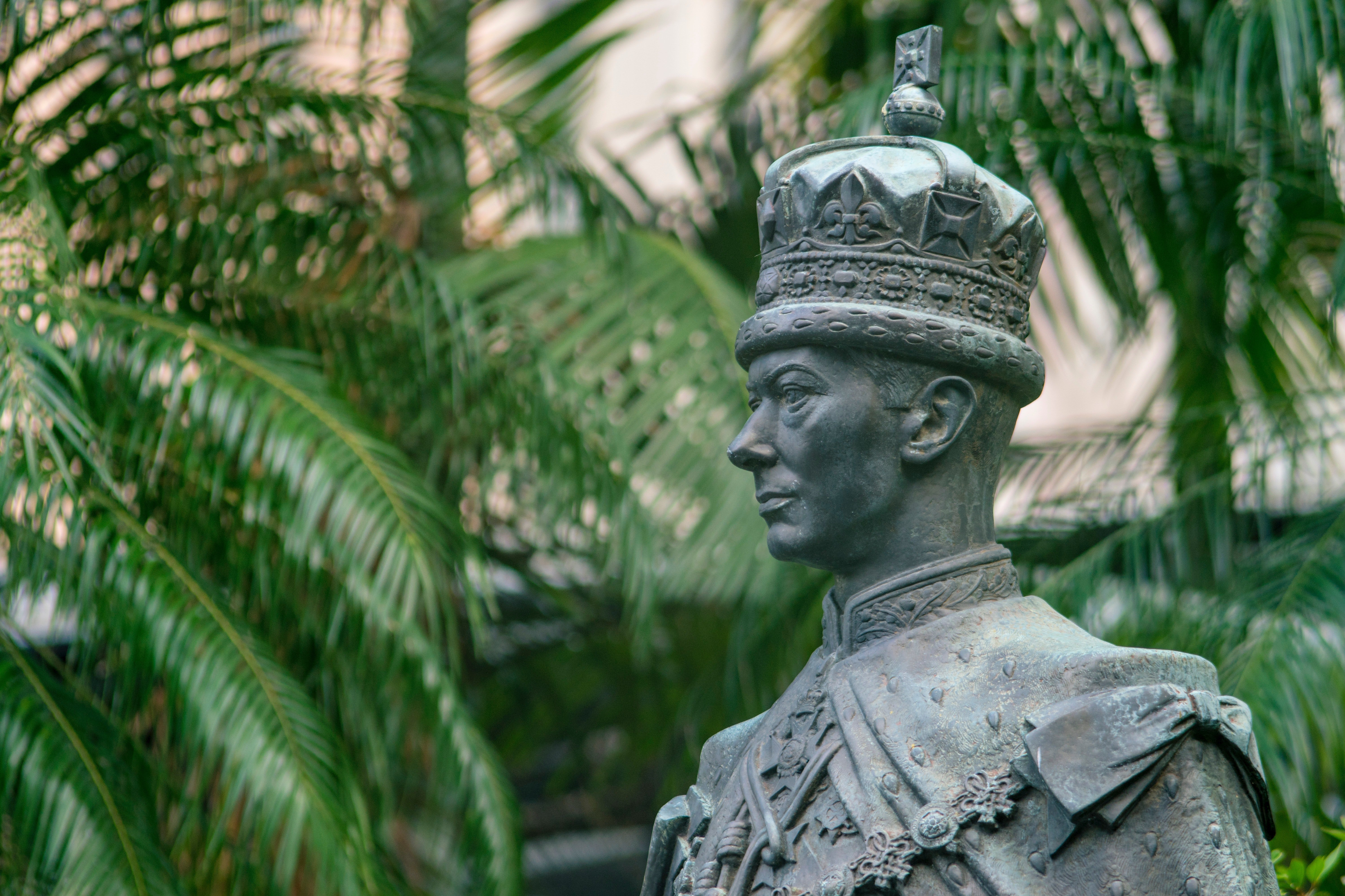 Pictured - A male statue near green palm trees | Source: Pexels 