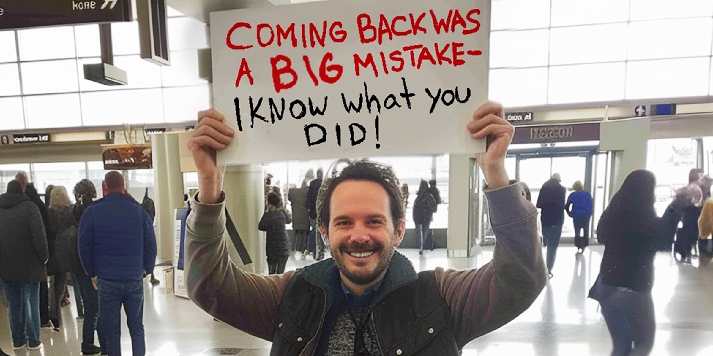 A man holding a sign in an airport | Source: Amomama